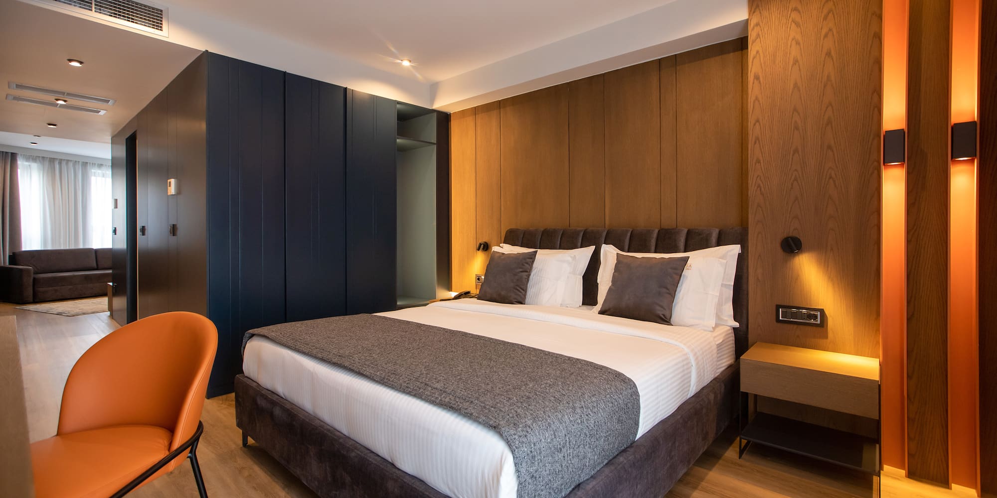 a bed with a chair and a desk in a room