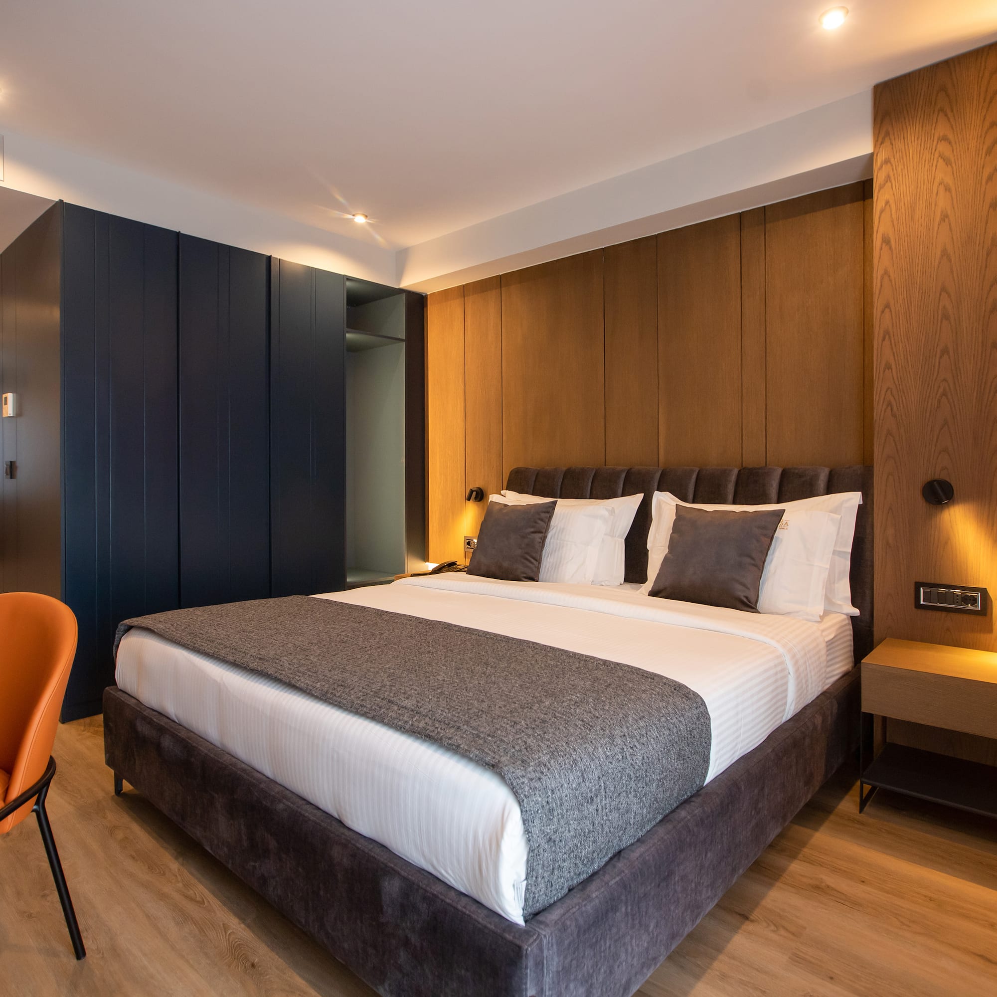 a bed with a chair and a desk in a room