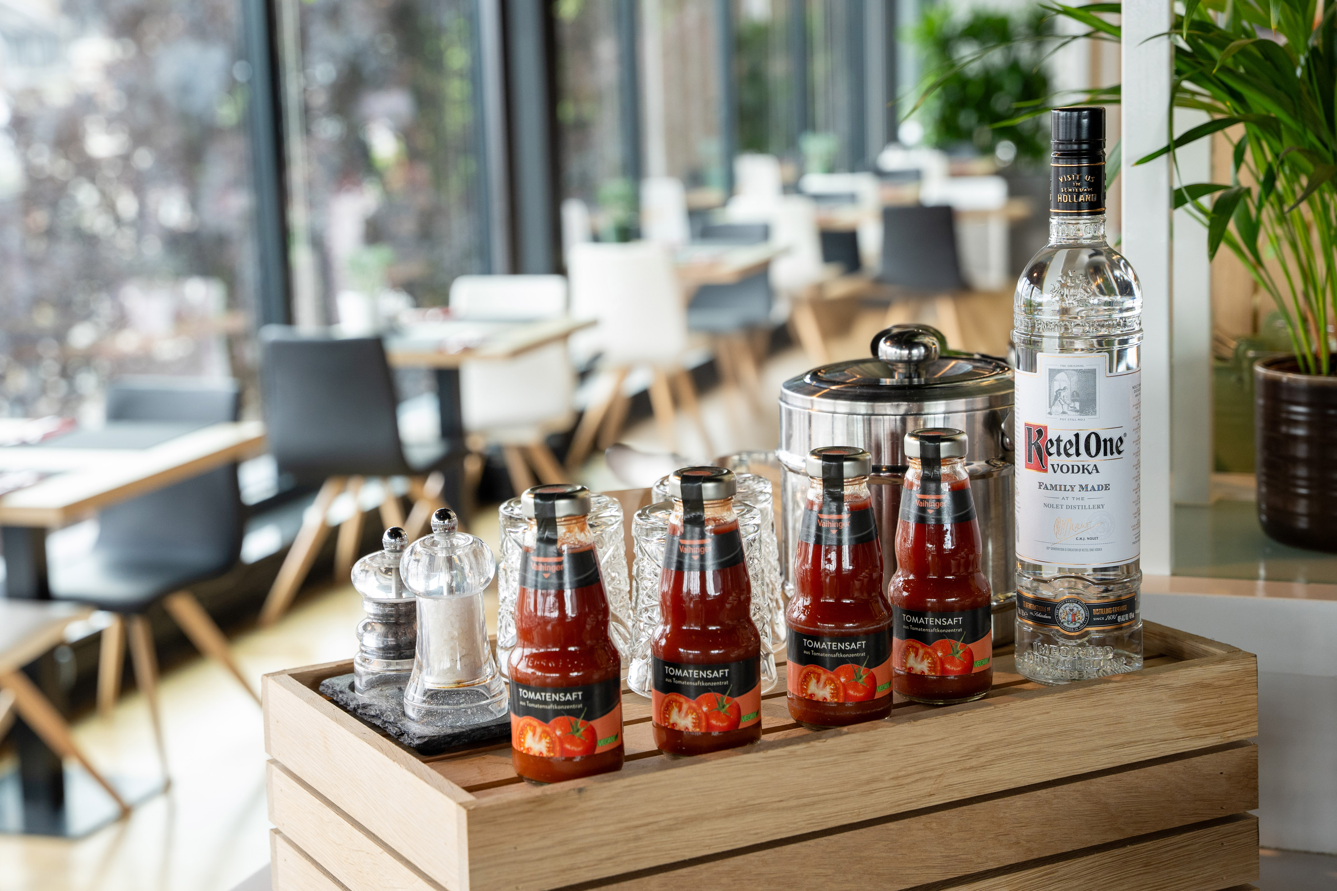 Ketel One Vodka, tomato juice, salt & pepper on tray in restaurant.