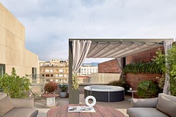 a patio with a hot tub and chairs