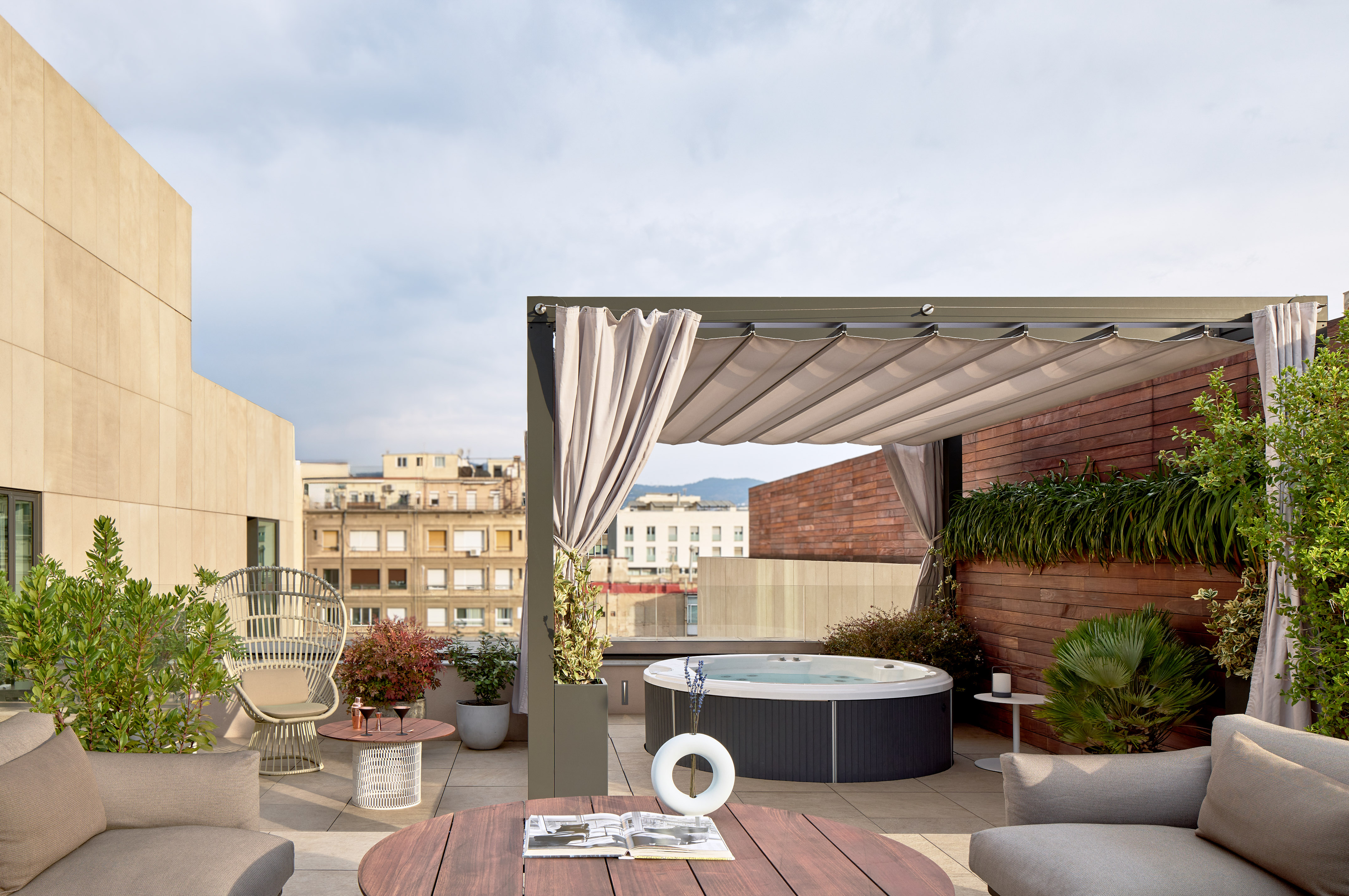Rooftop terrace with hot tub, modern outdoor furniture, pergola, and city views.