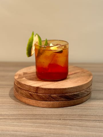 a glass with a drink and lime slices on top of it