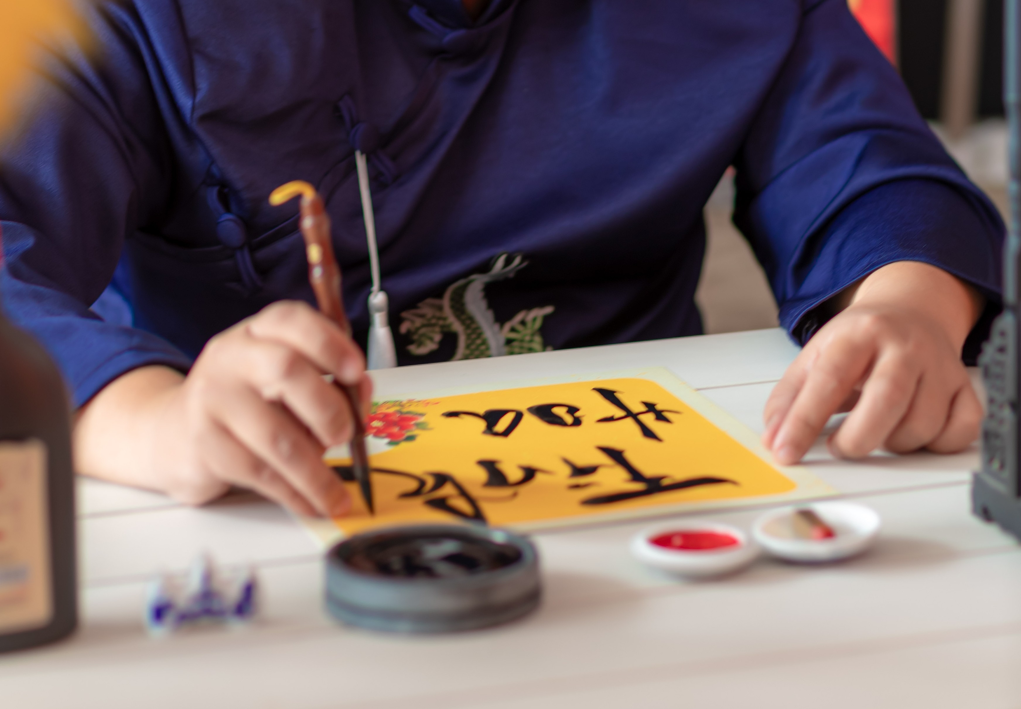 a person writing on a yellow paper