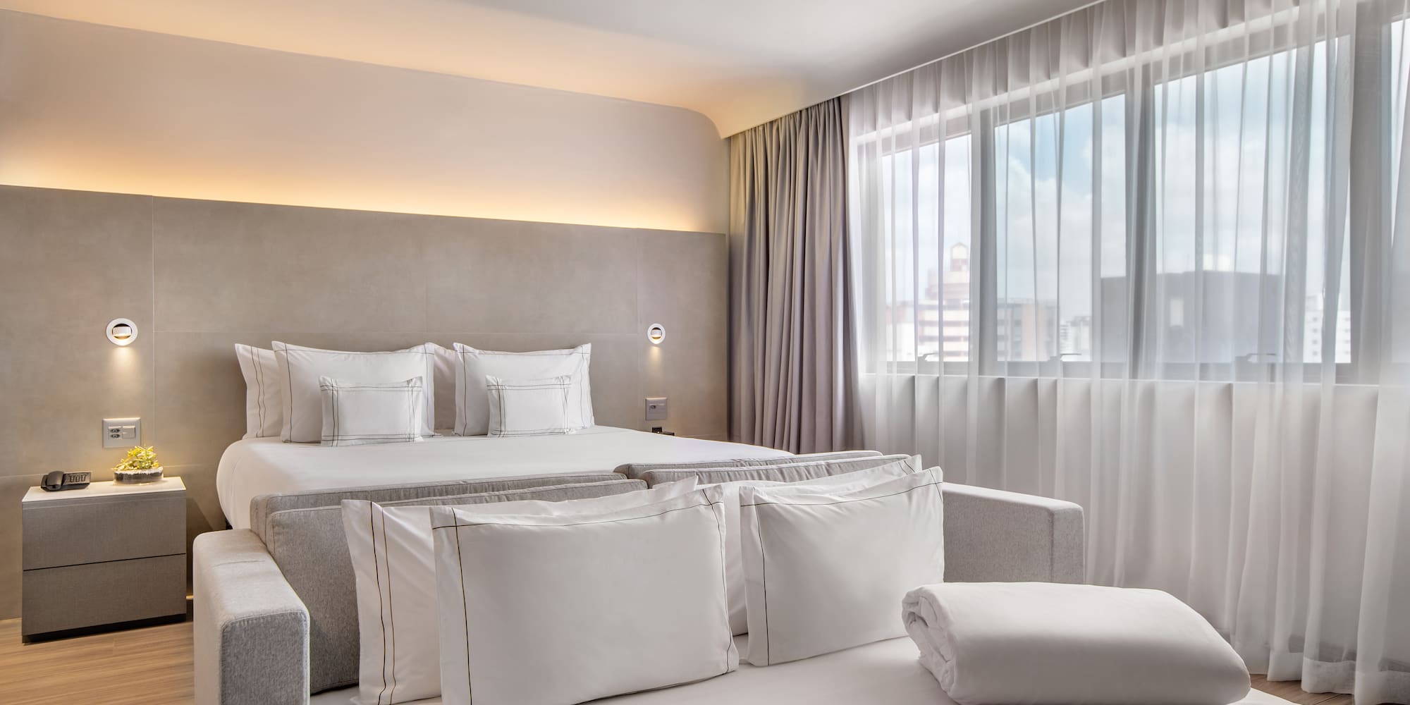 a bed with pillows and a bed in a room with curtains