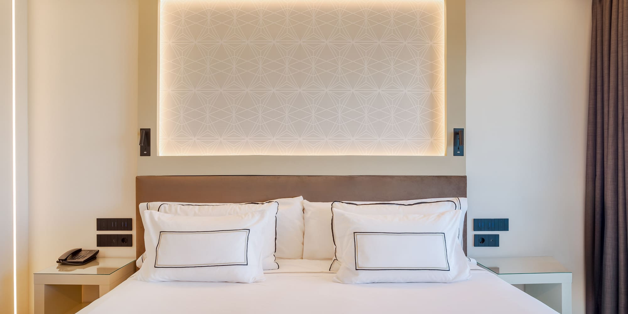 a bed with white sheets and pillows