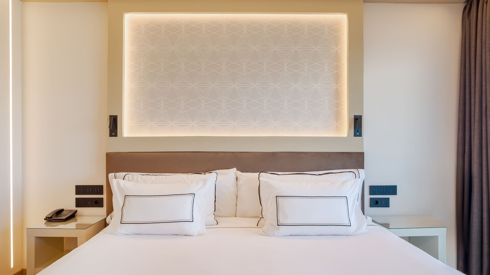 a bed with white sheets and pillows