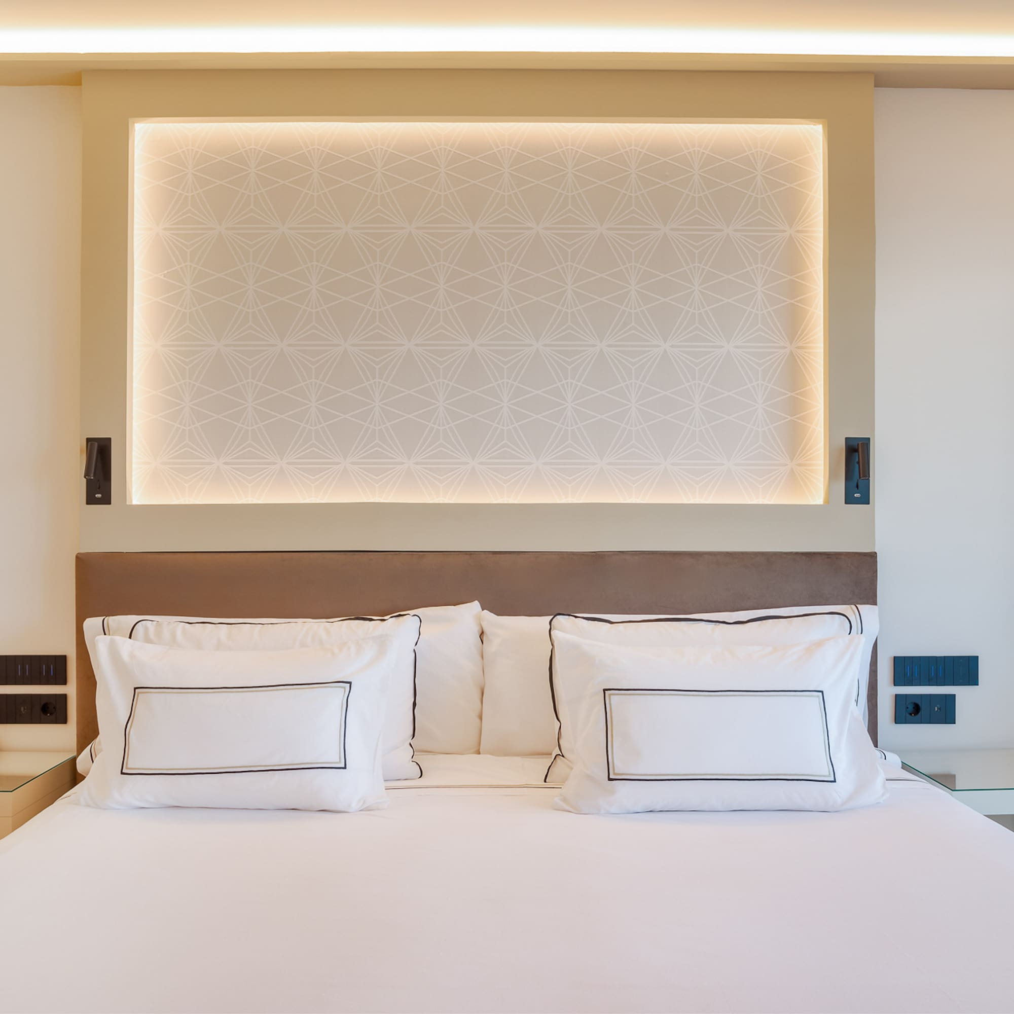 a bed with white sheets and pillows