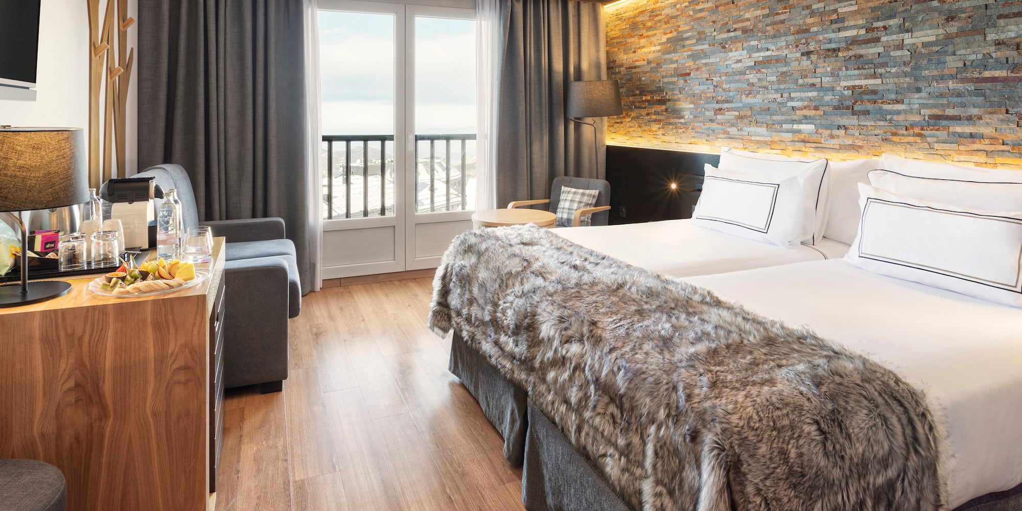 a room with two beds and a table with a glass door