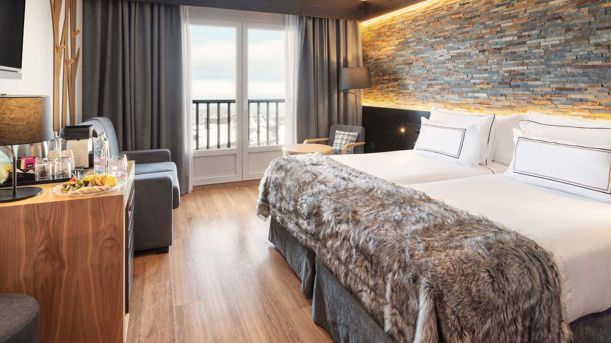 a room with two beds and a table with a glass door