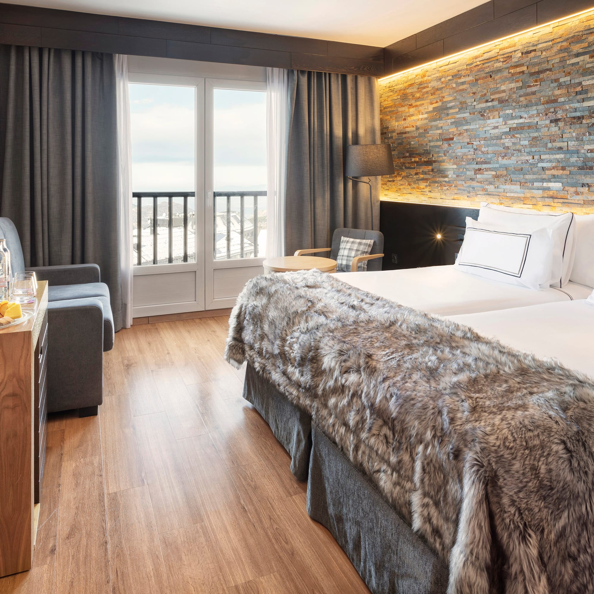 a room with two beds and a table with a glass door