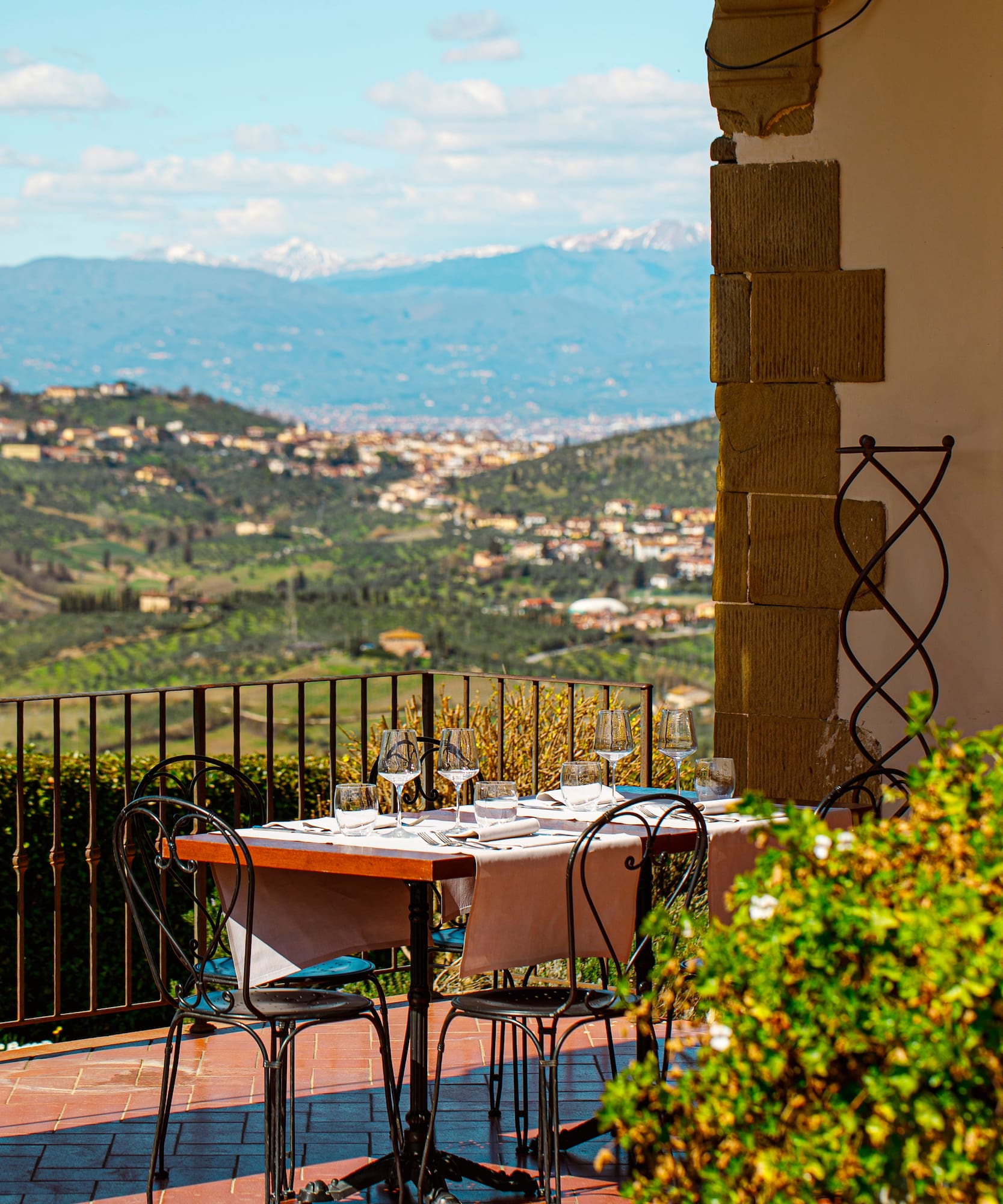 a table and chairs outside with a view of a valley in the background