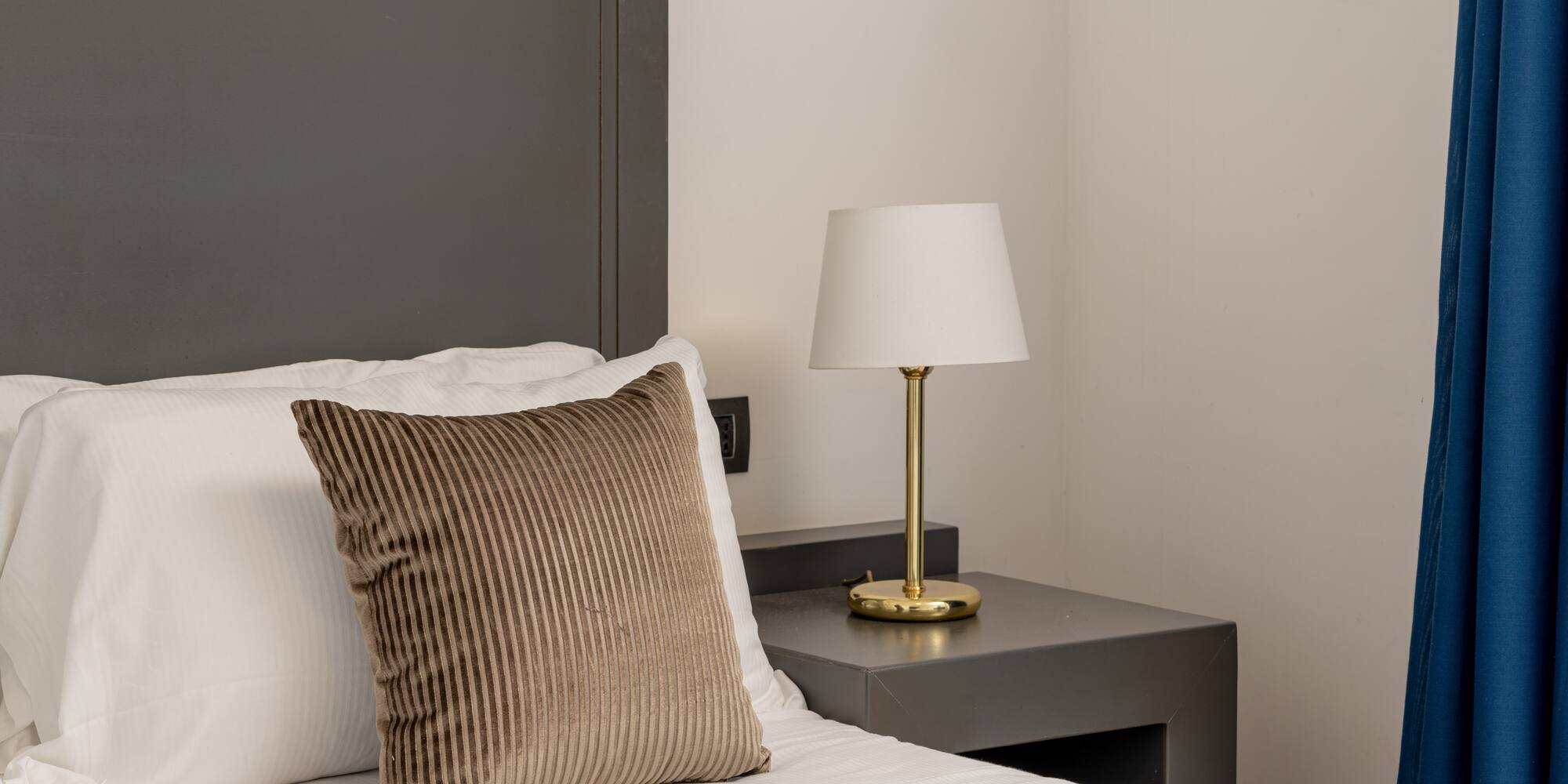 a bed with a lamp on a table