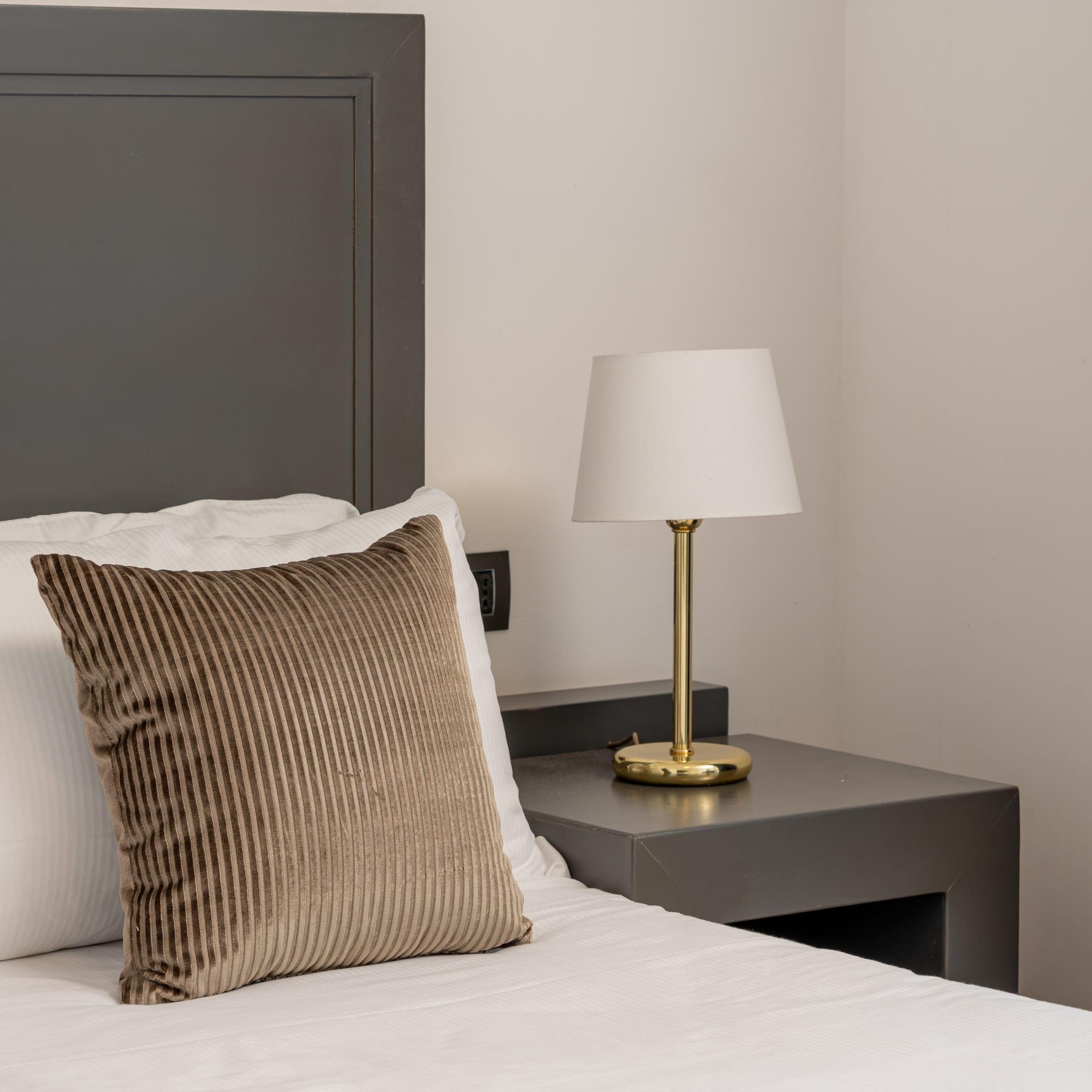 a bed with a lamp on a table