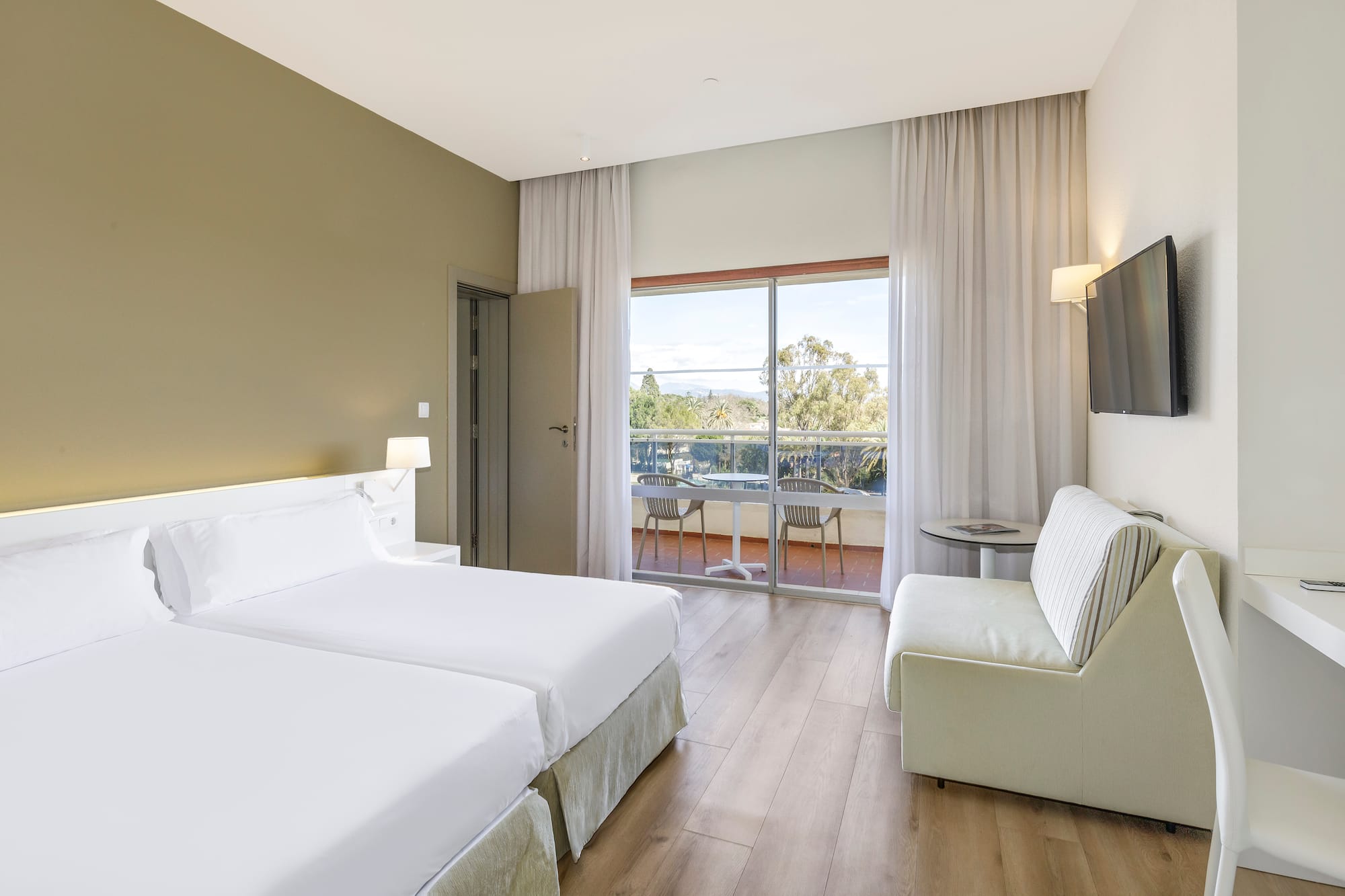 a room with two beds and a television