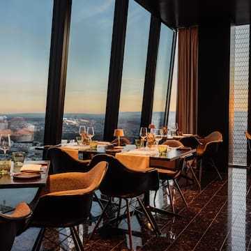 a table with wine glasses and a vase of flowers in front of a window
