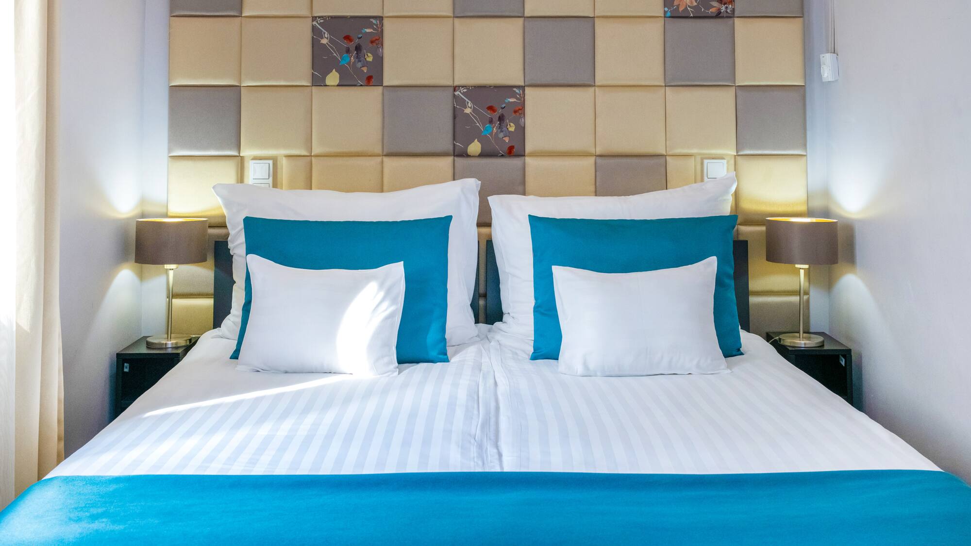 a bed with pillows and a lamp on the side