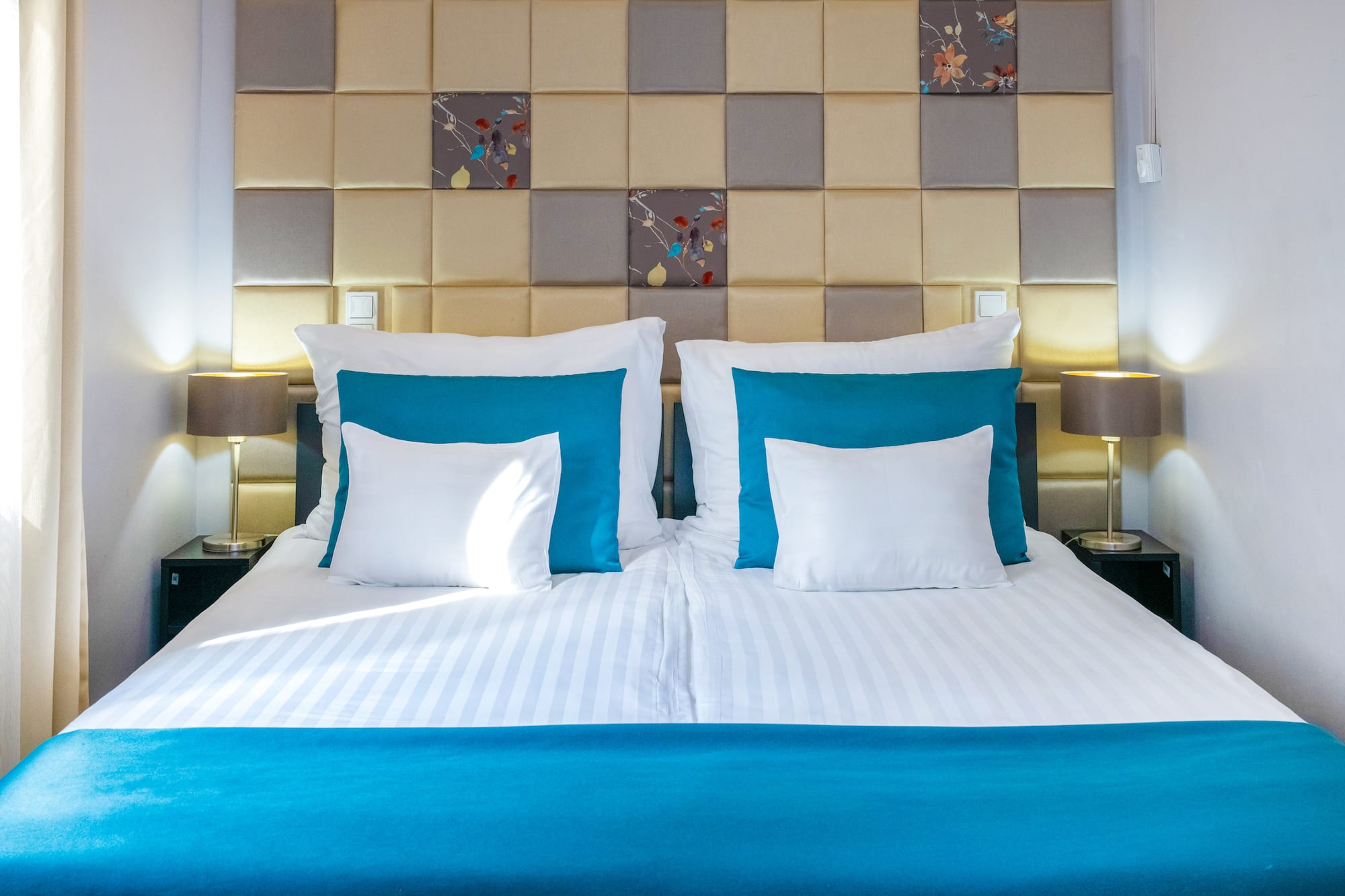 a bed with pillows and a lamp on the side