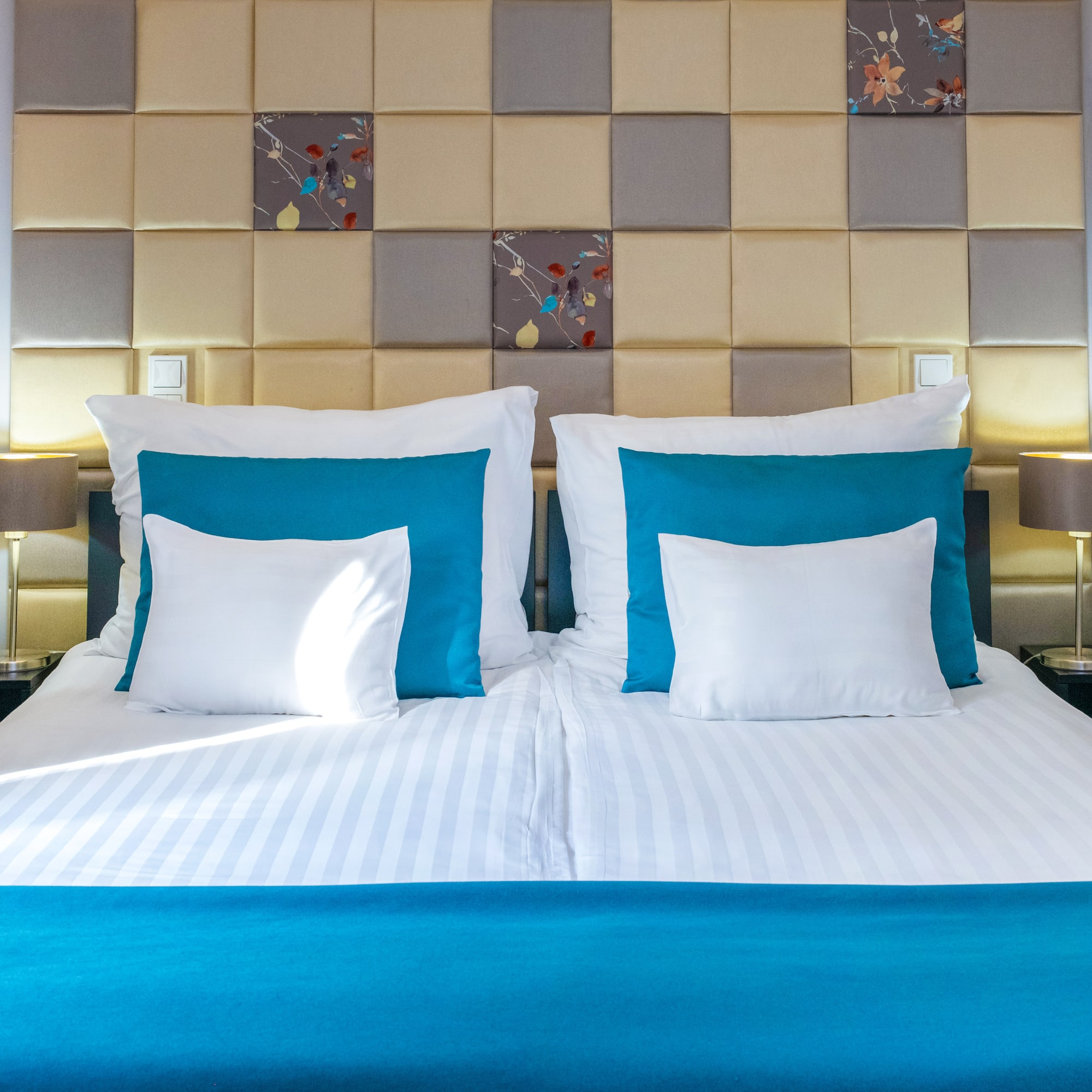 a bed with pillows and a lamp on the side