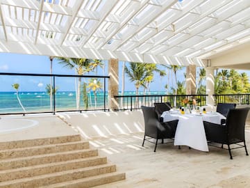 a table set up on a patio with a view of the ocean