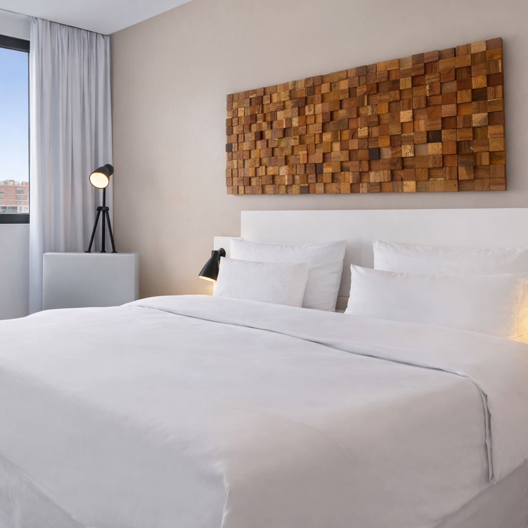 a bed with white sheets and pillows in a room with a lamp and a window