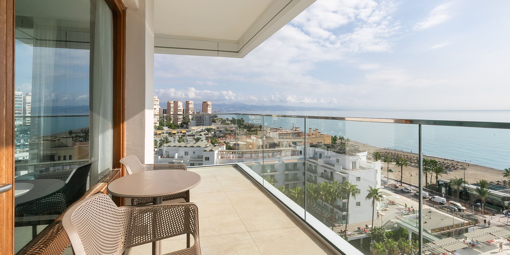 a balcony with chairs and a view of the ocean