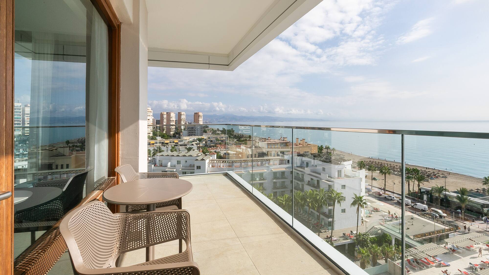 a balcony with chairs and a view of the ocean