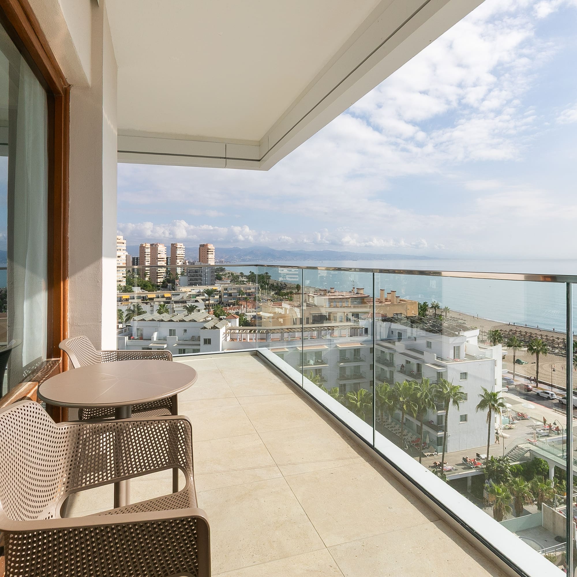 a balcony with chairs and a view of the ocean