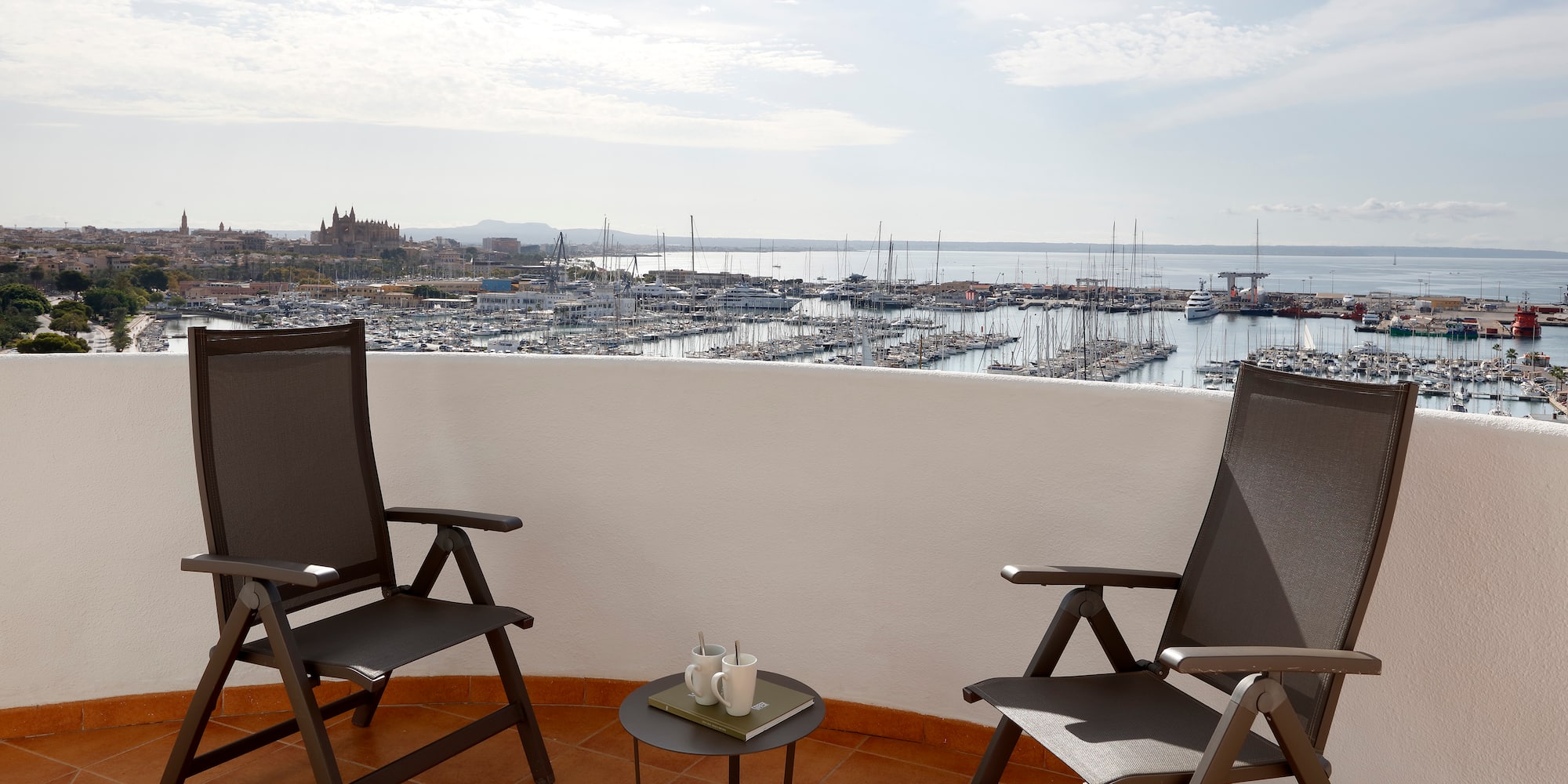 two chairs on a balcony overlooking a city