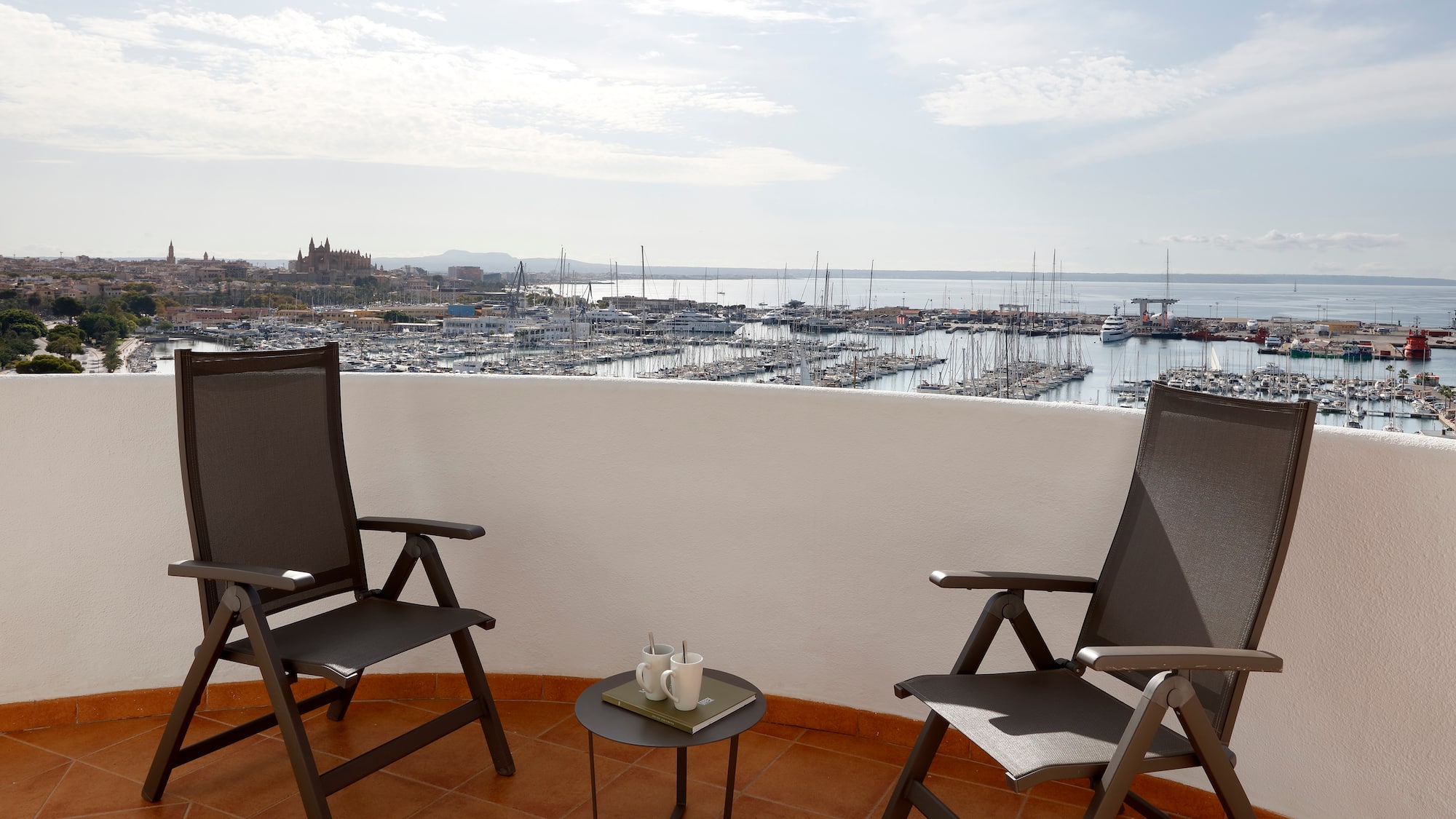two chairs on a balcony overlooking a city