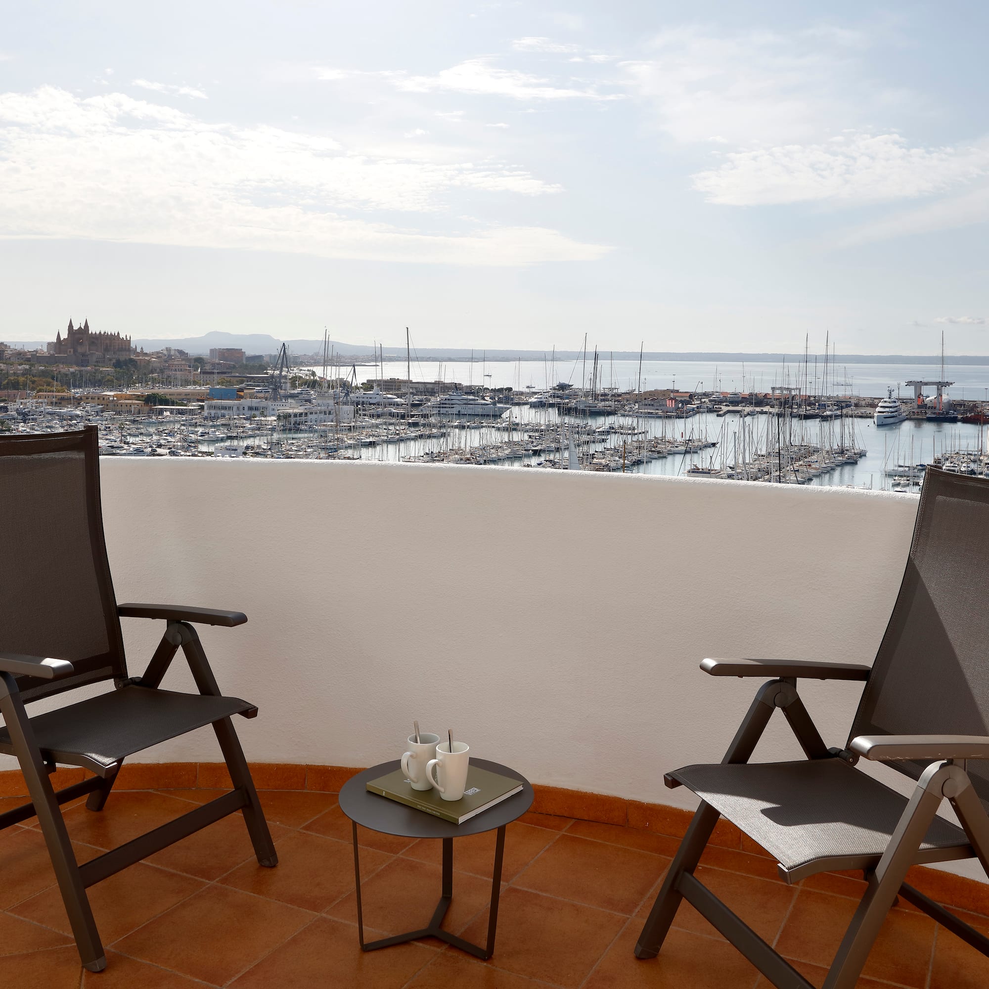 two chairs on a balcony overlooking a city