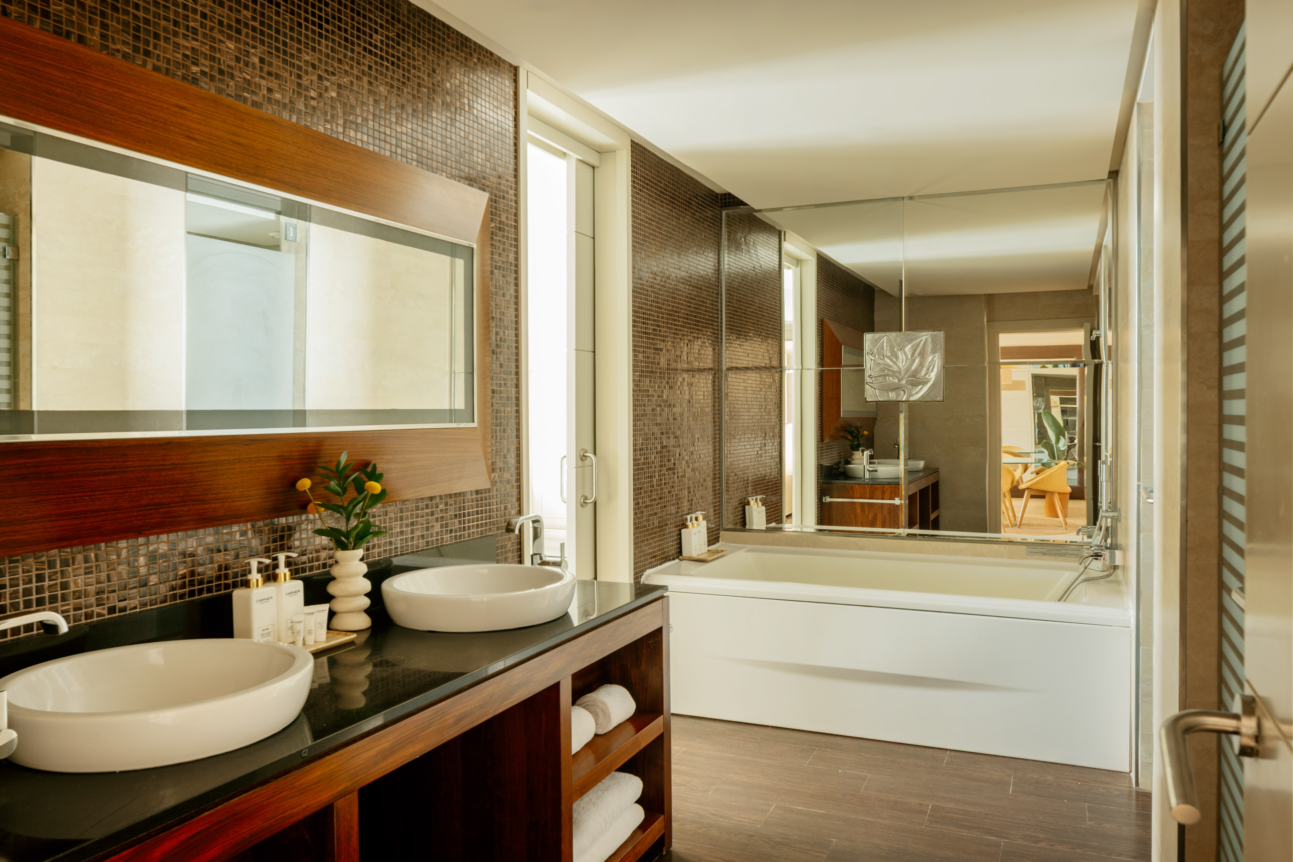 Luxury modern bathroom with double vanity sinks, mosaic tiles, and white bathtub.