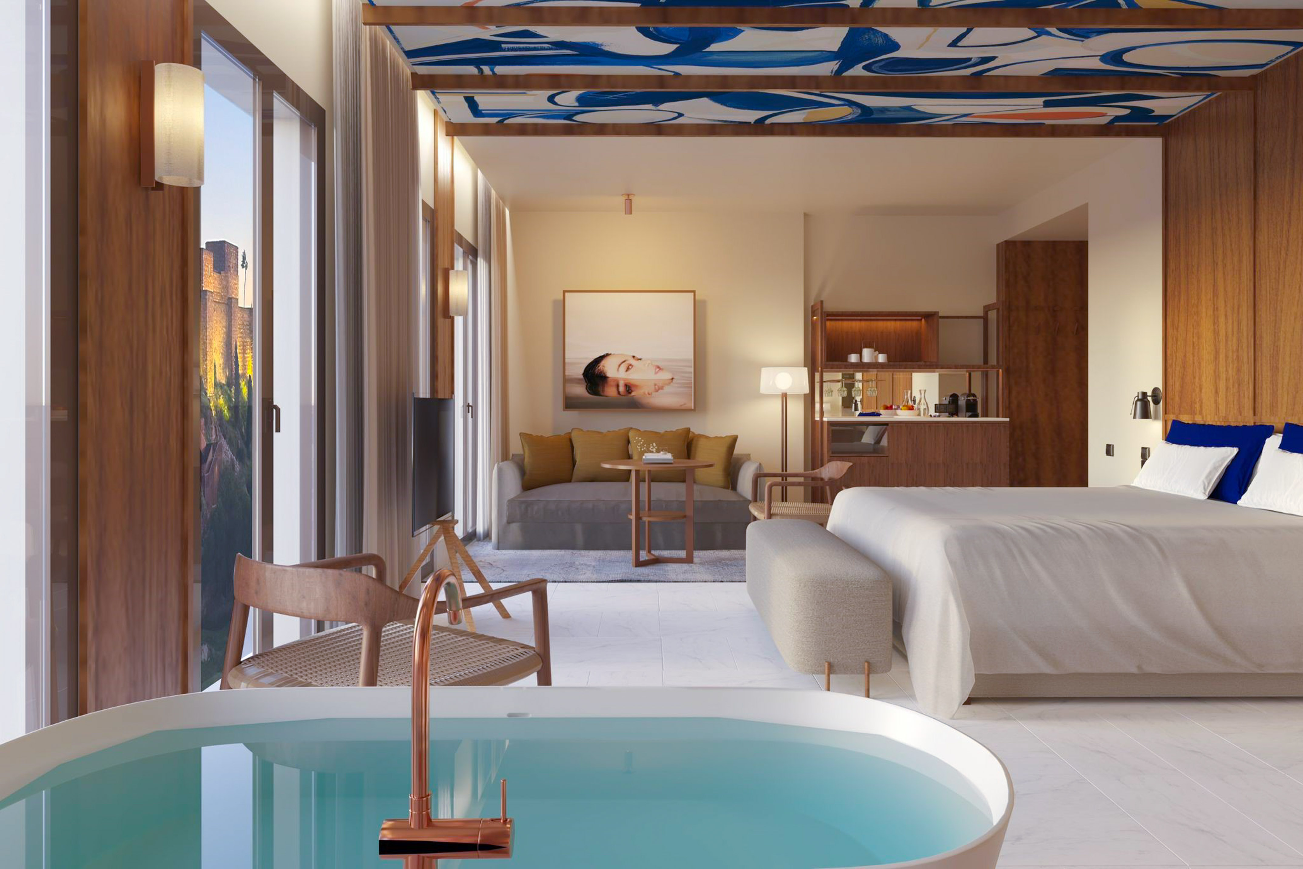 Luxury resort suite with bed, living area, modern tub, and scenic view.