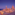 Historic Valletta skyline at twilight with illuminated dome, steeple, and coastline.