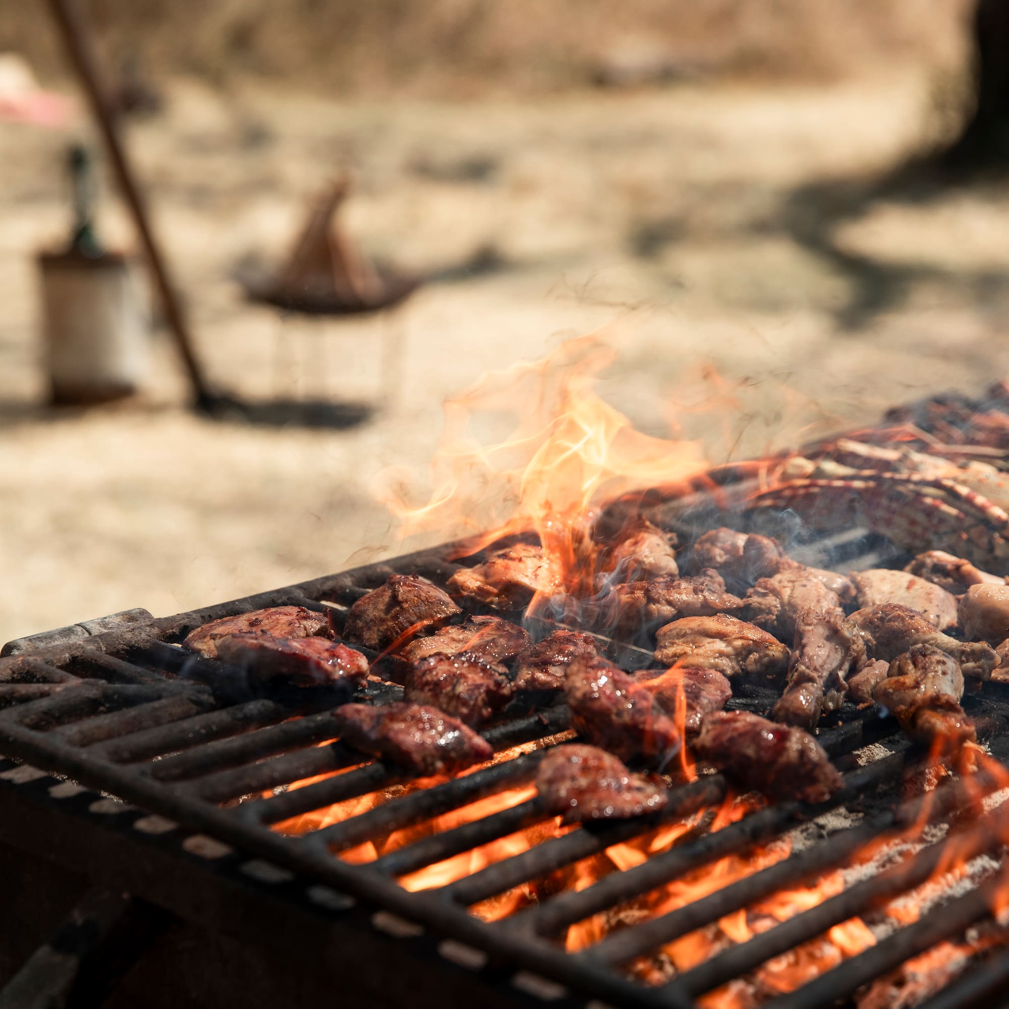 meat on a grill with flames