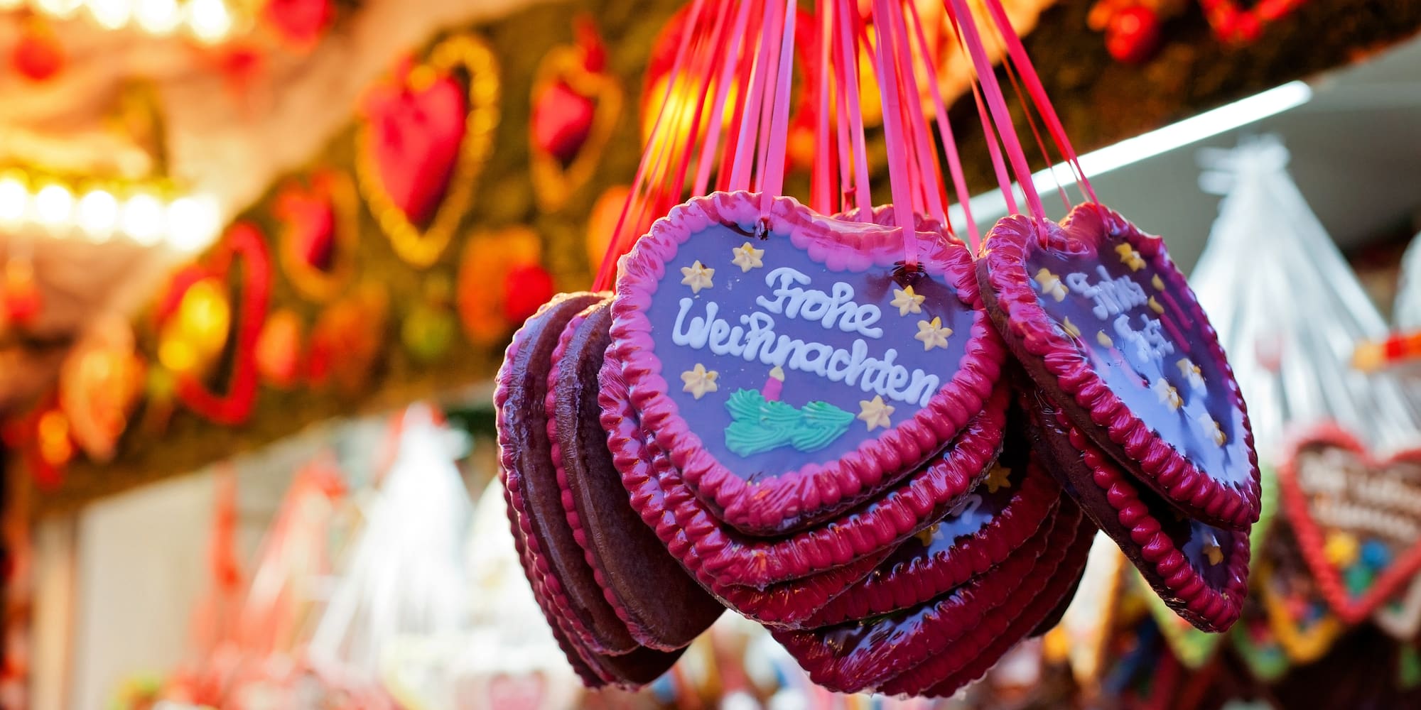 German gingerbread hearts "Frohe Weihnachten" hanging at Christmas market.