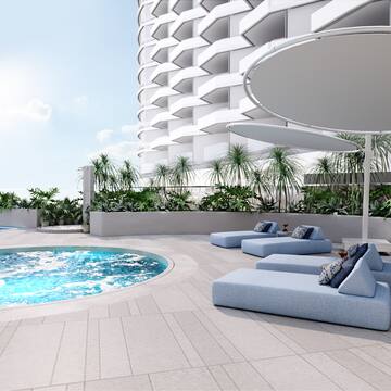 a pool with lounge chairs and a large building