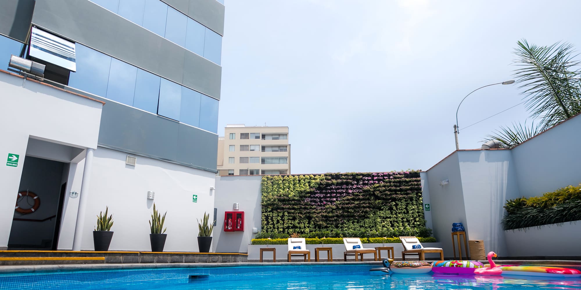 a pool with chairs and a building in the background