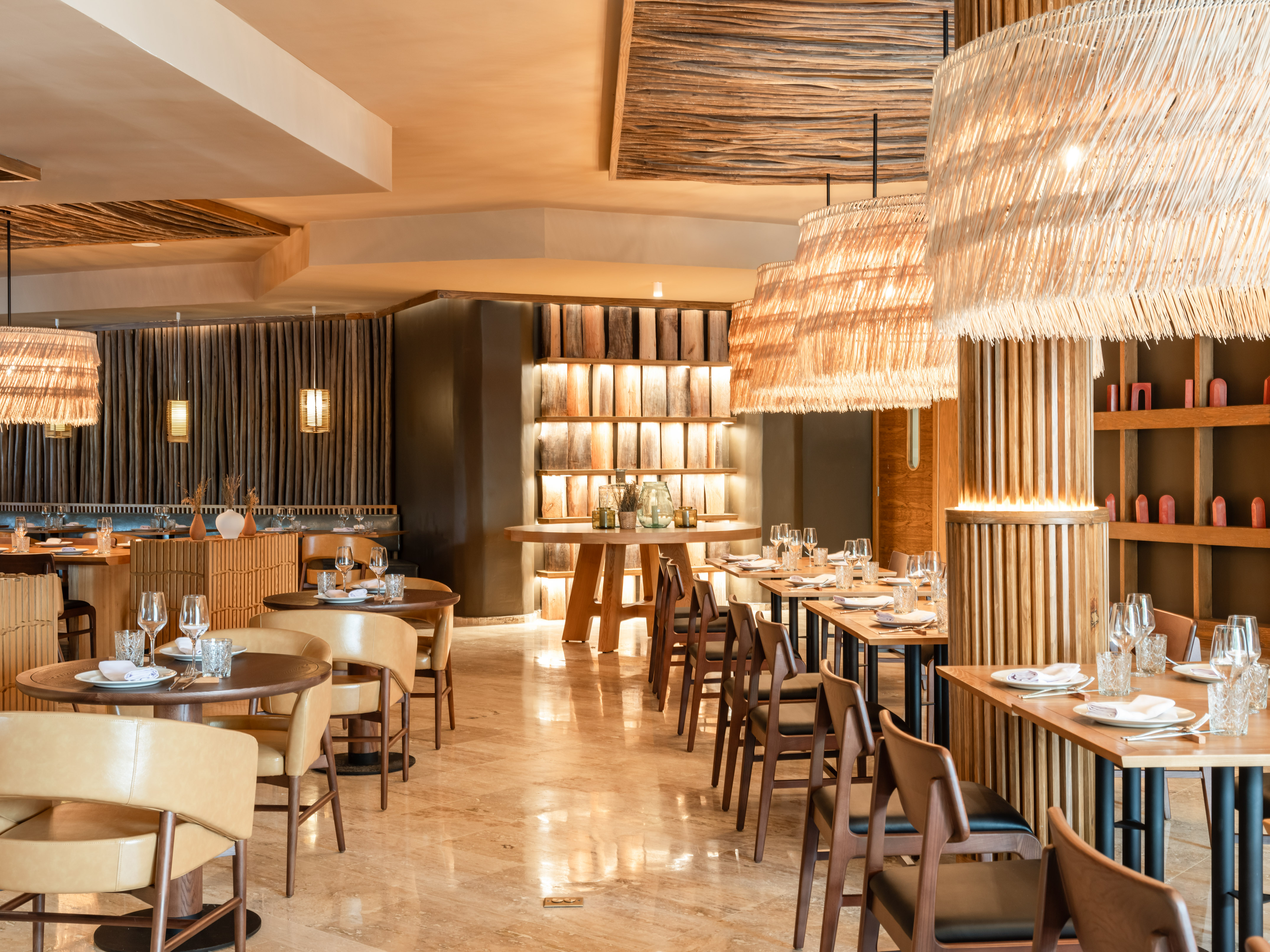 Stylish restaurant dining room with wood, rattan lamps, and marble floor.