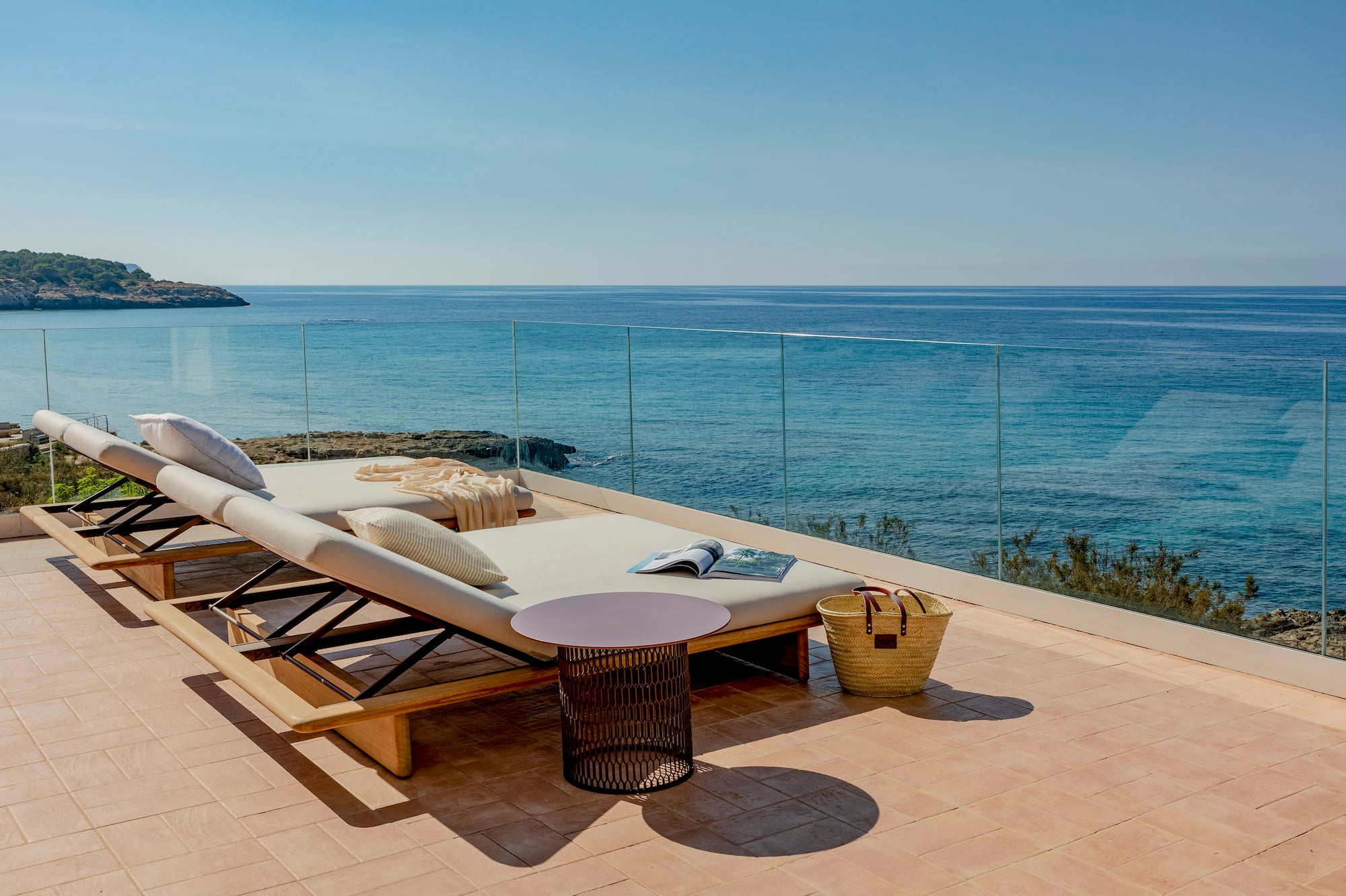a deck with a chair and a table overlooking the ocean