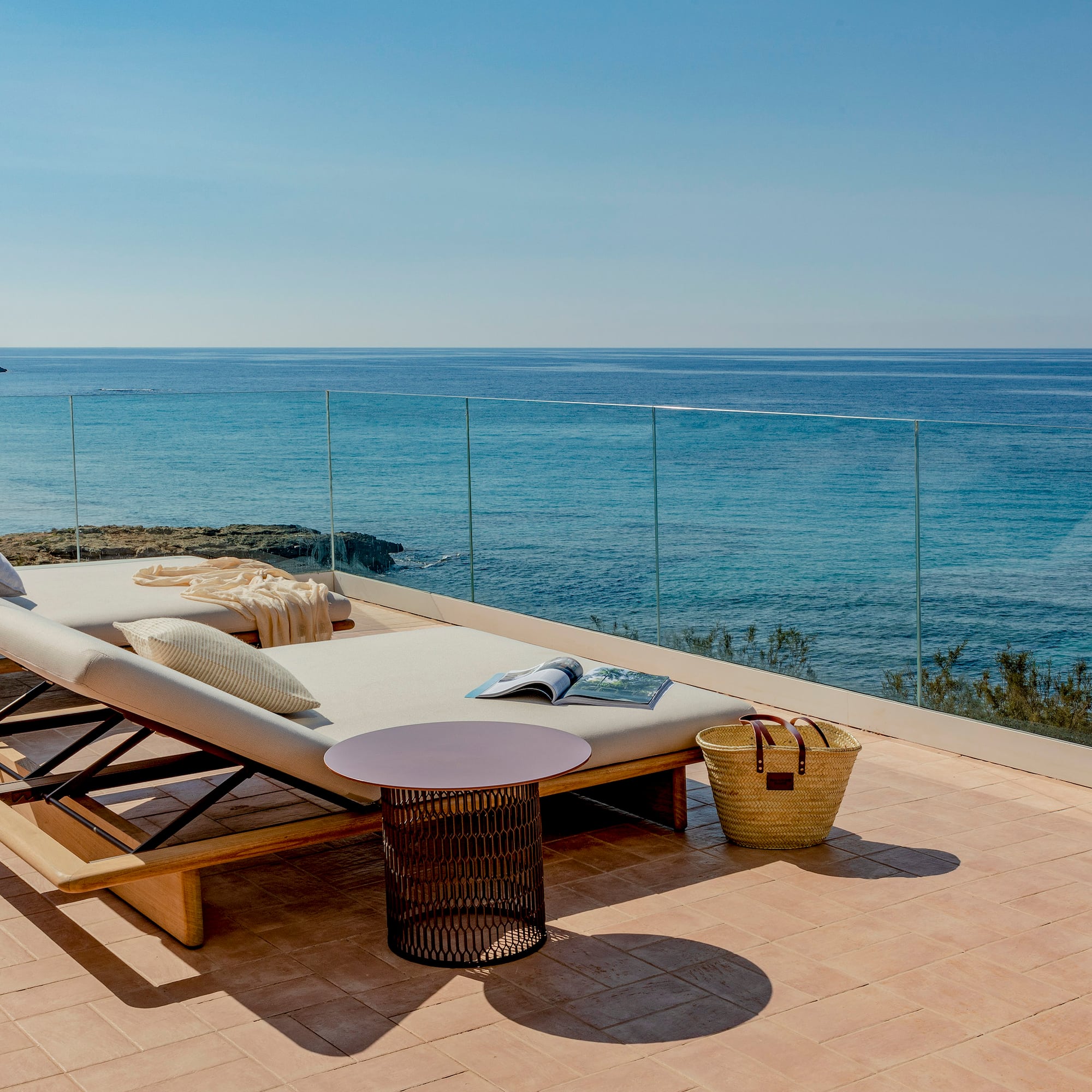 a deck with a chair and a table overlooking the ocean