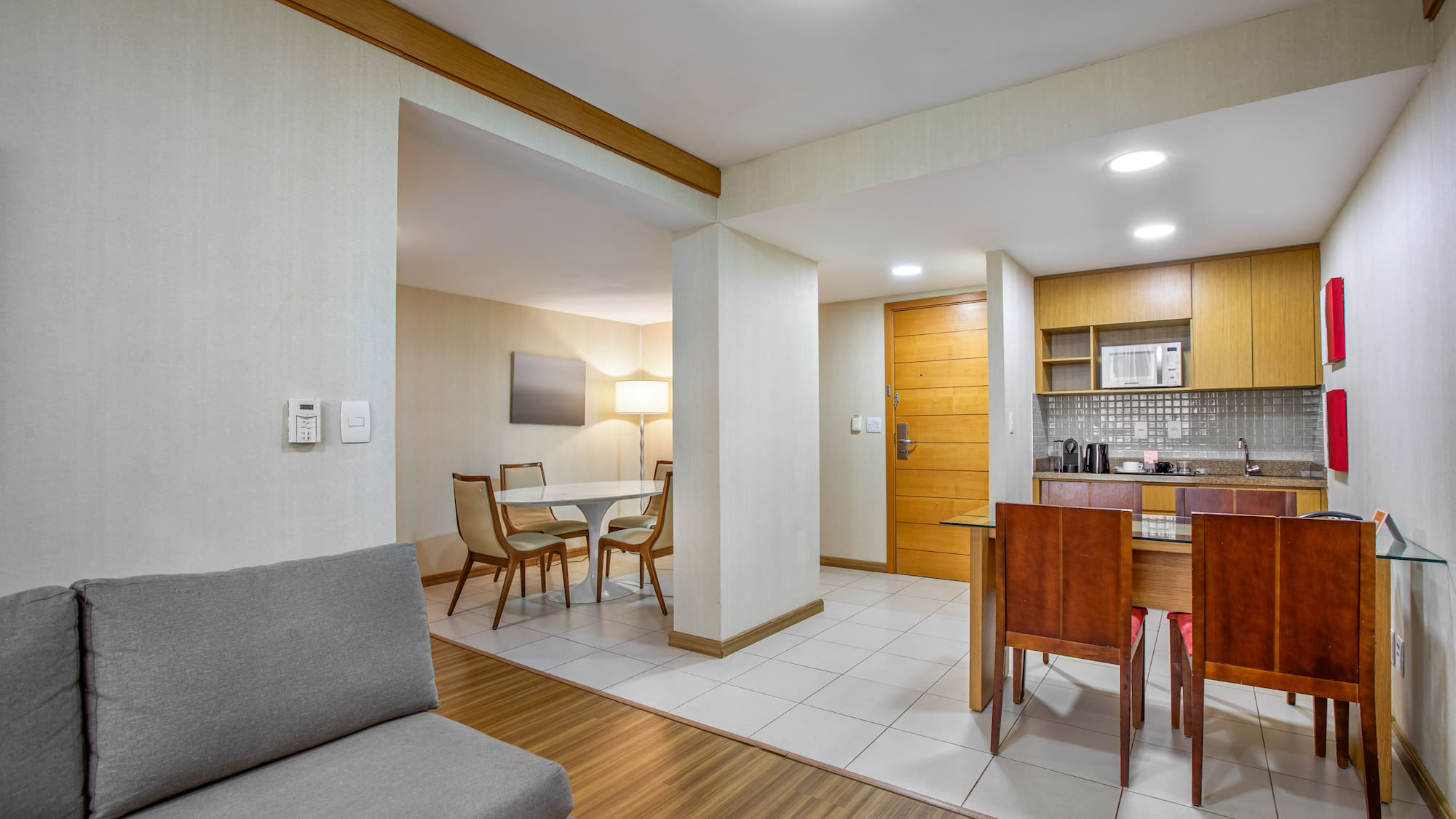 Apartment suite with living area, dining space, and modern kitchenette.