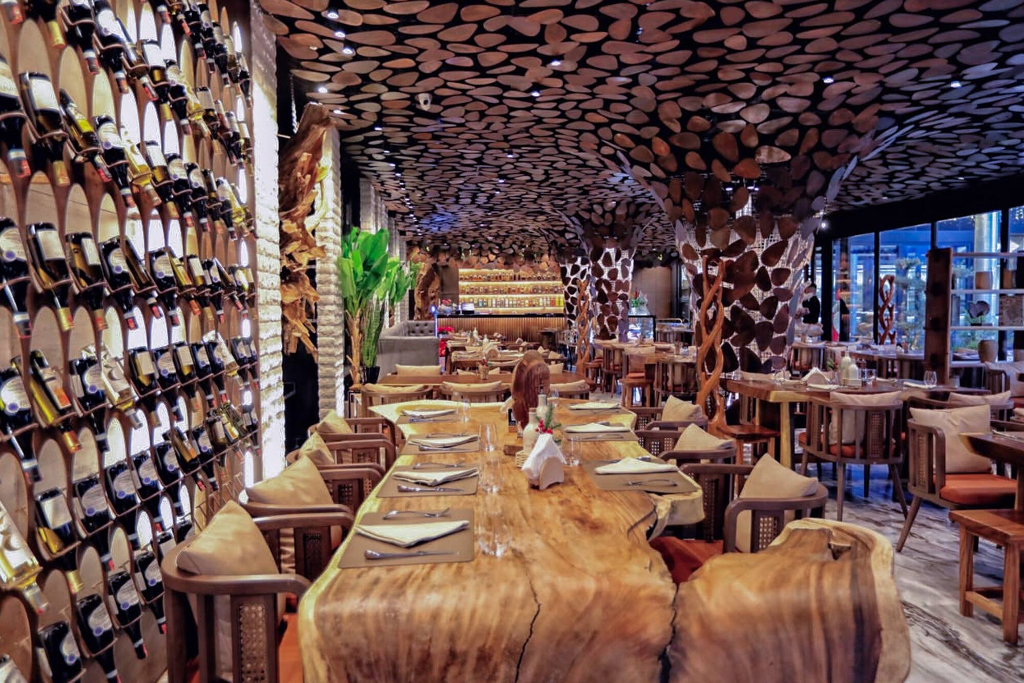 Restaurant interior, wine wall, wooden slab tables, and rustic wood decor.