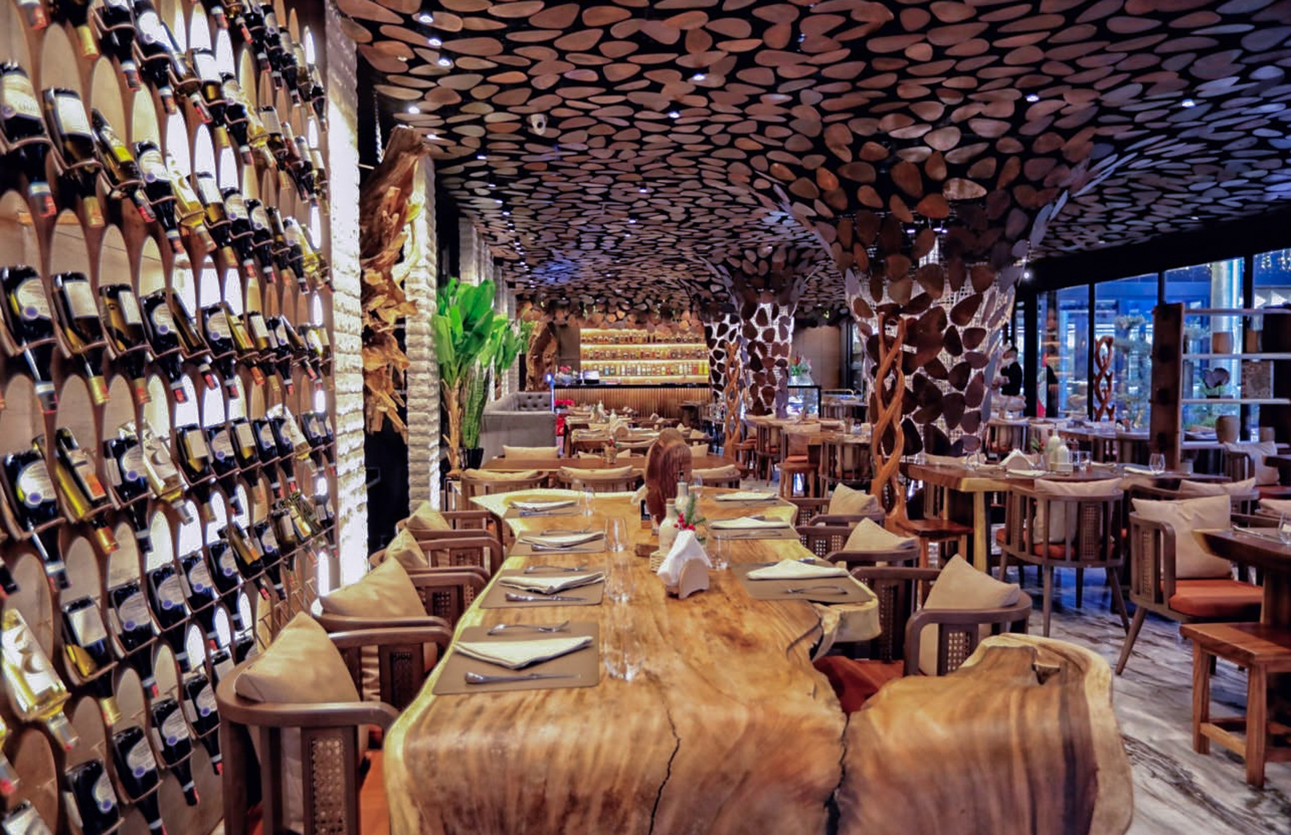Restaurant interior, wine wall, wooden slab tables, and rustic wood decor.