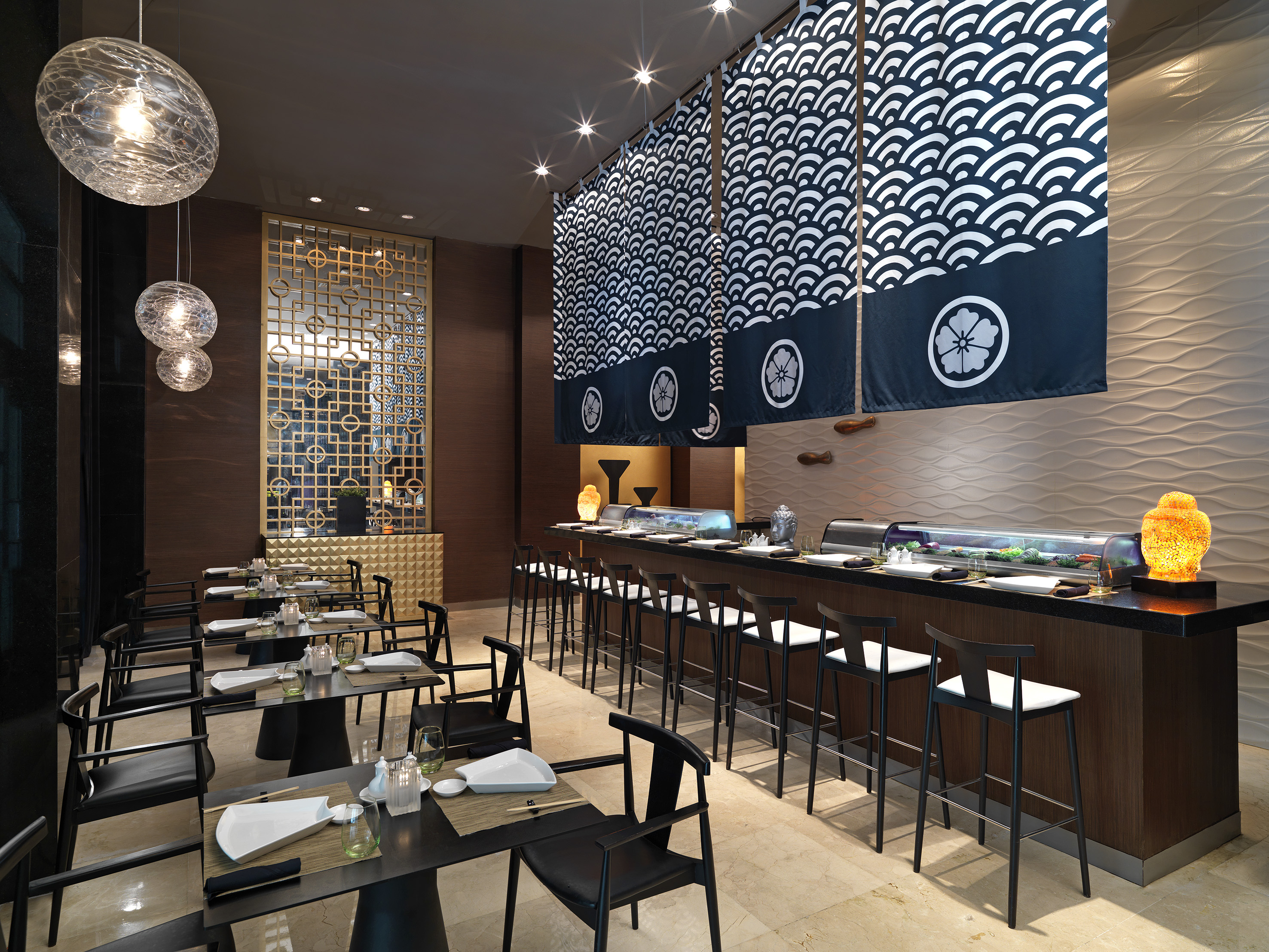 Modern Japanese restaurant interior: sushi bar, noren curtains, dining tables.