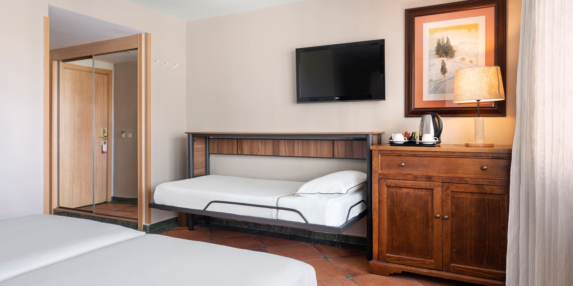 a room with two beds and a television