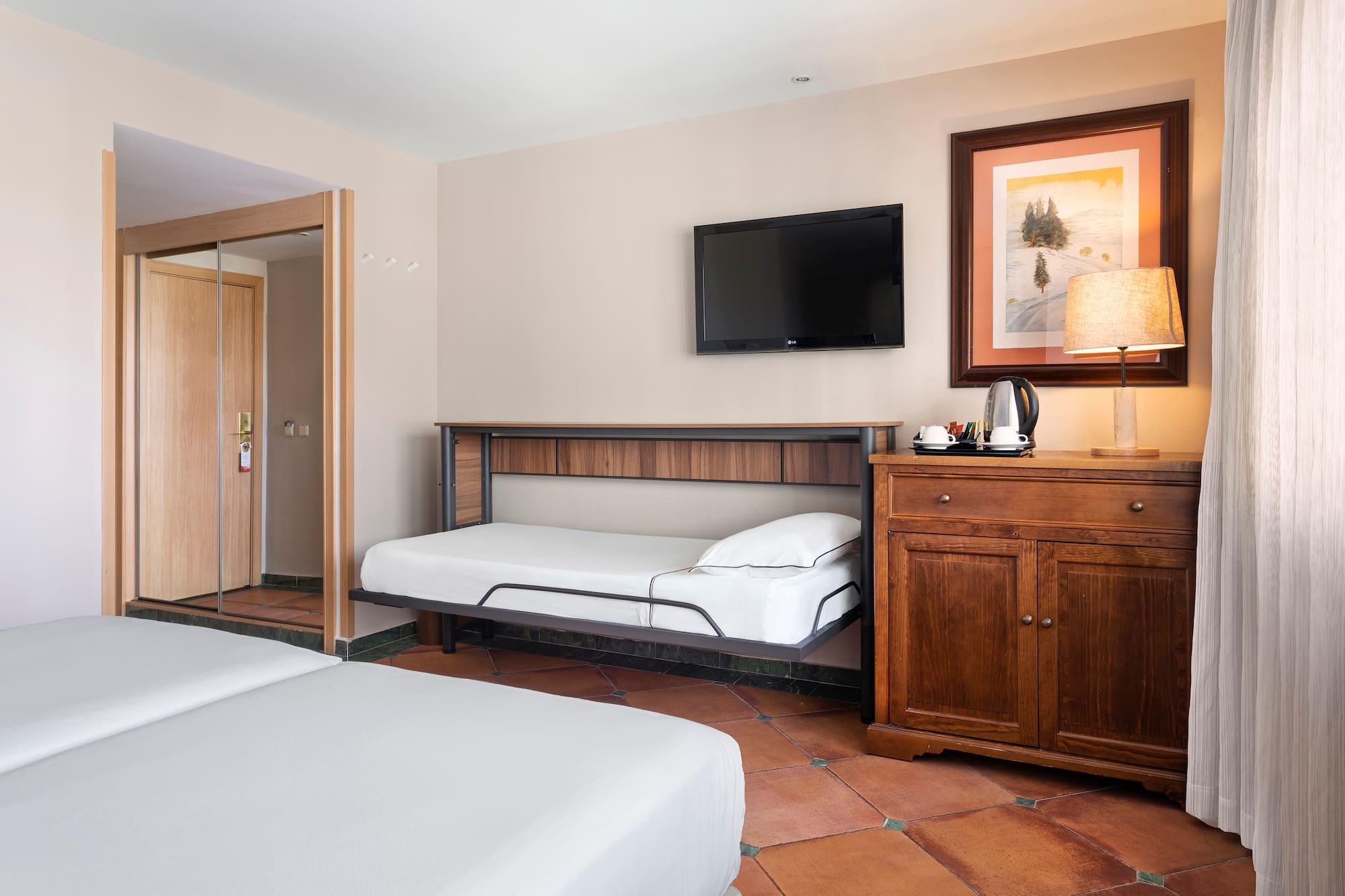 a room with two beds and a television