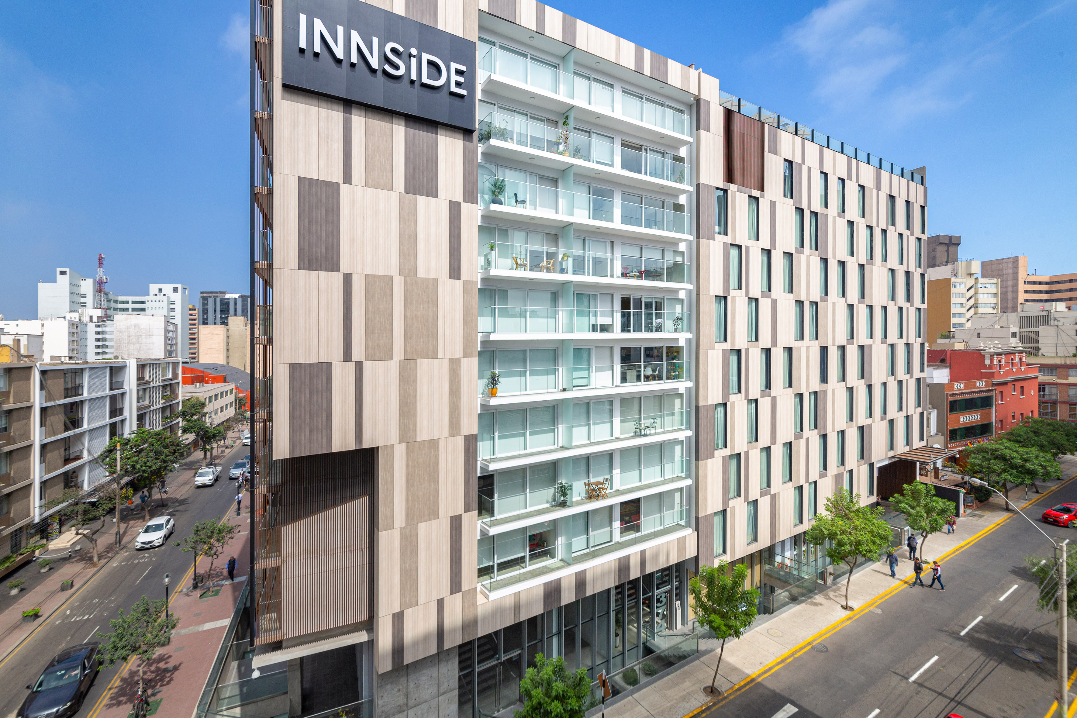 INNSiDE hotel with modern facade, glass balconies, and city street.