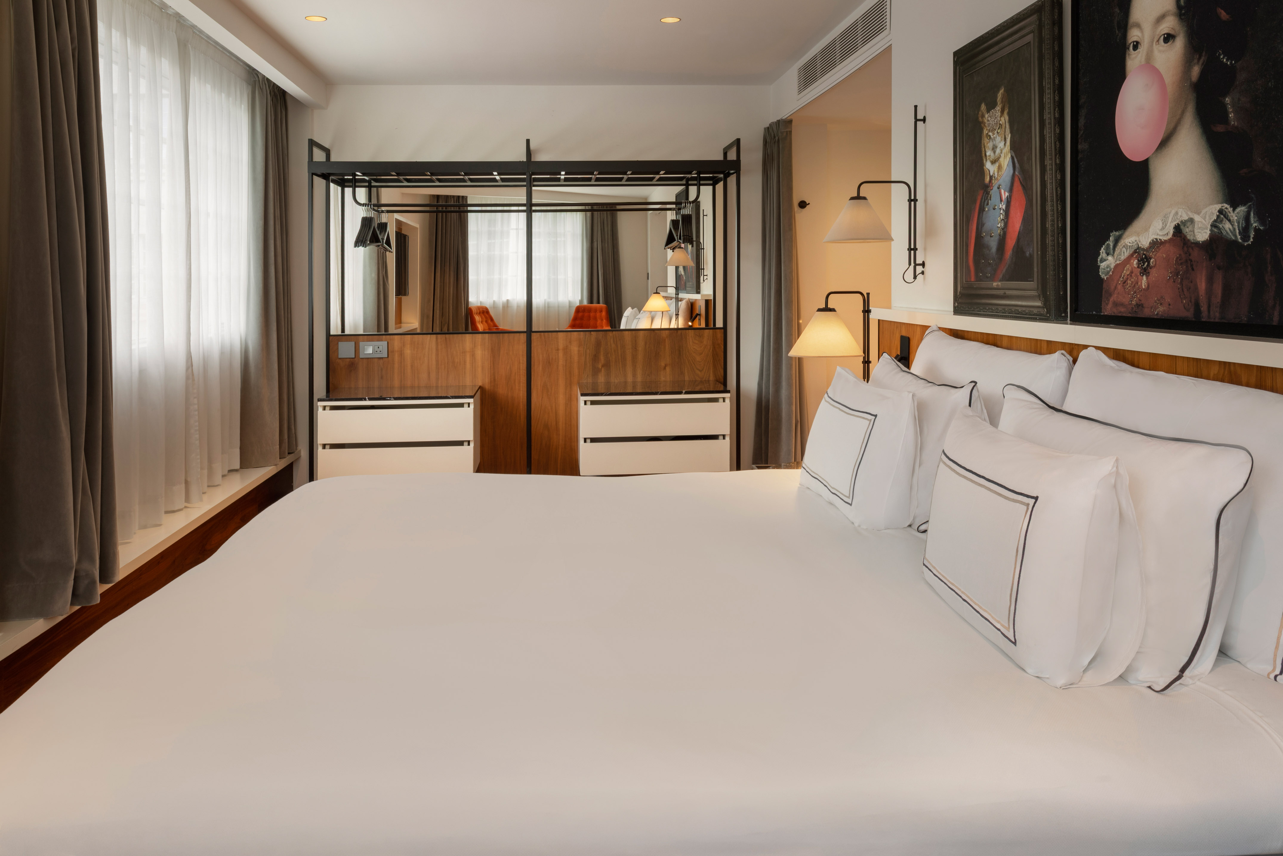 Stylish hotel bedroom with a large bed, modern wardrobe, and unique wall art.