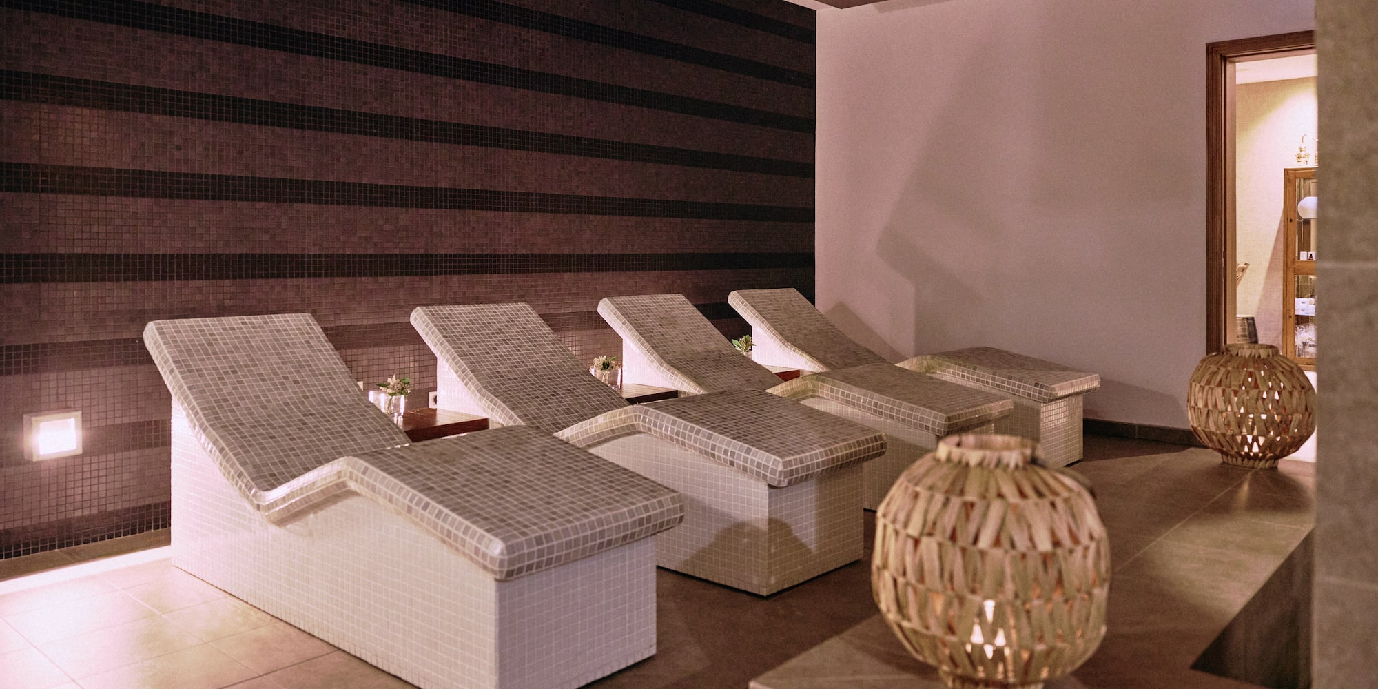 Spa relaxation area with mosaic lounge chairs and warm lighting.