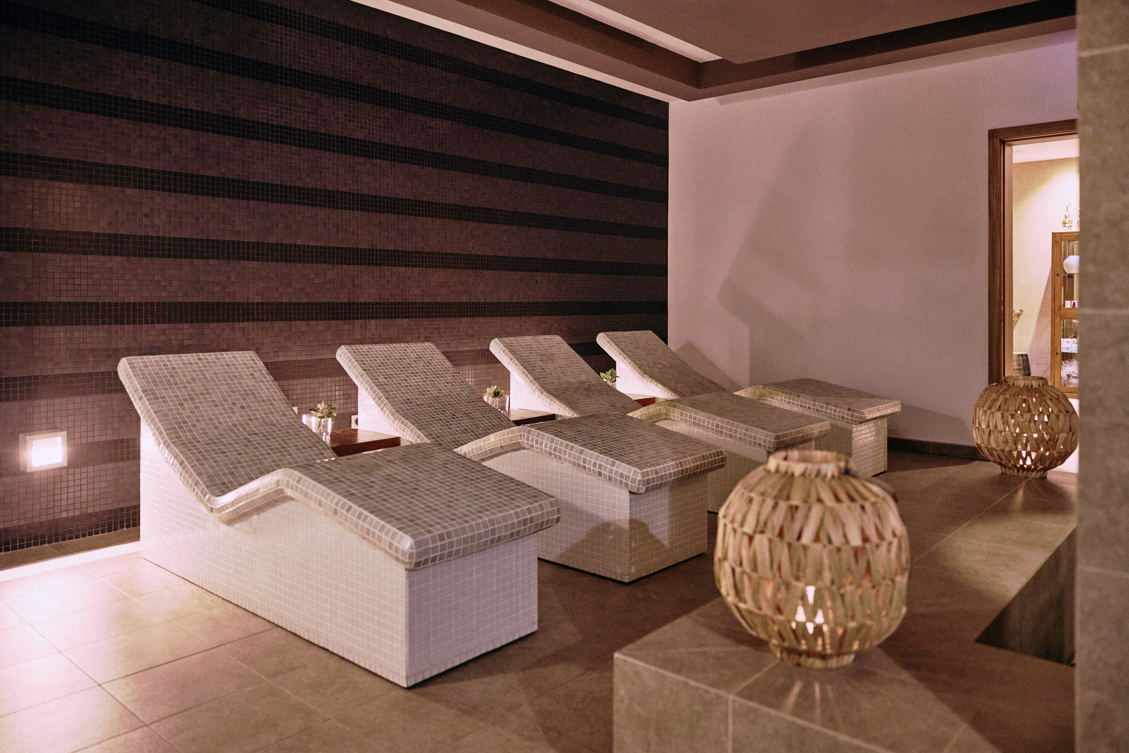 Spa relaxation area with mosaic lounge chairs and warm lighting.